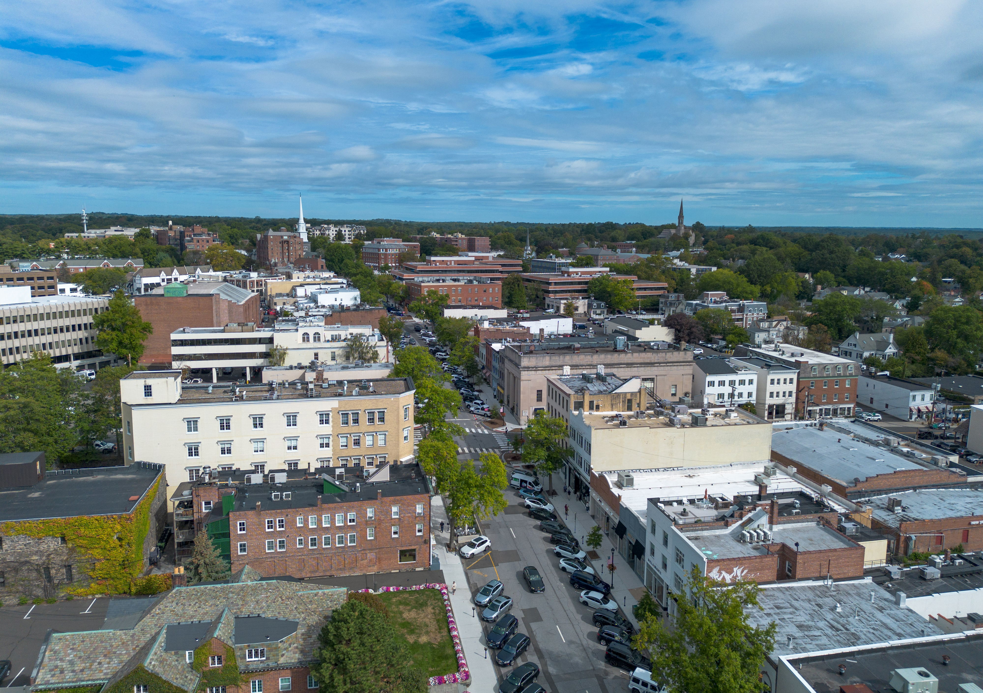 Aerial view of a small New England downtown with brick buildings and tree-lined streets.