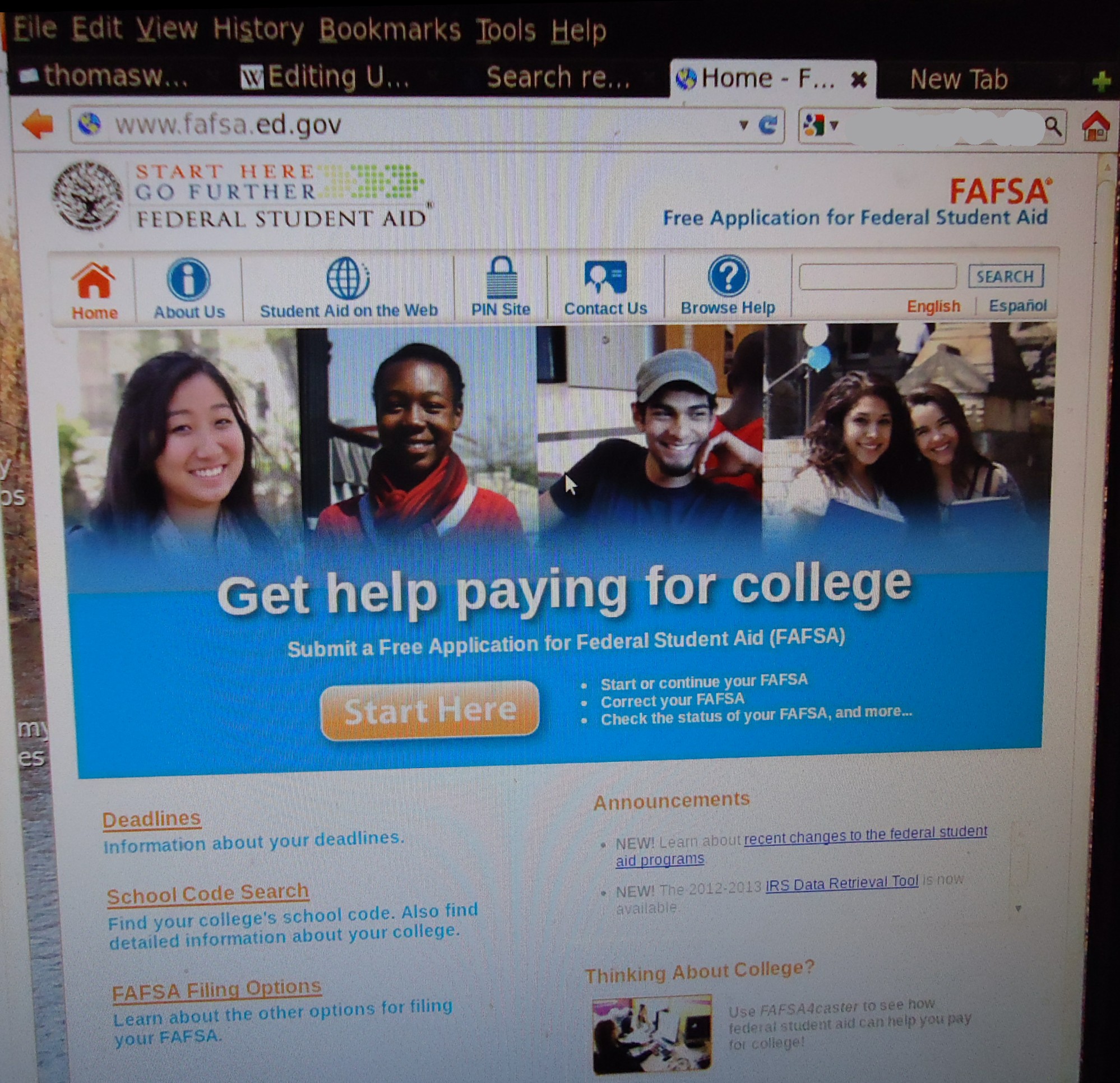 Computer monitor displaying the FAFSA website homepage with navigation links.