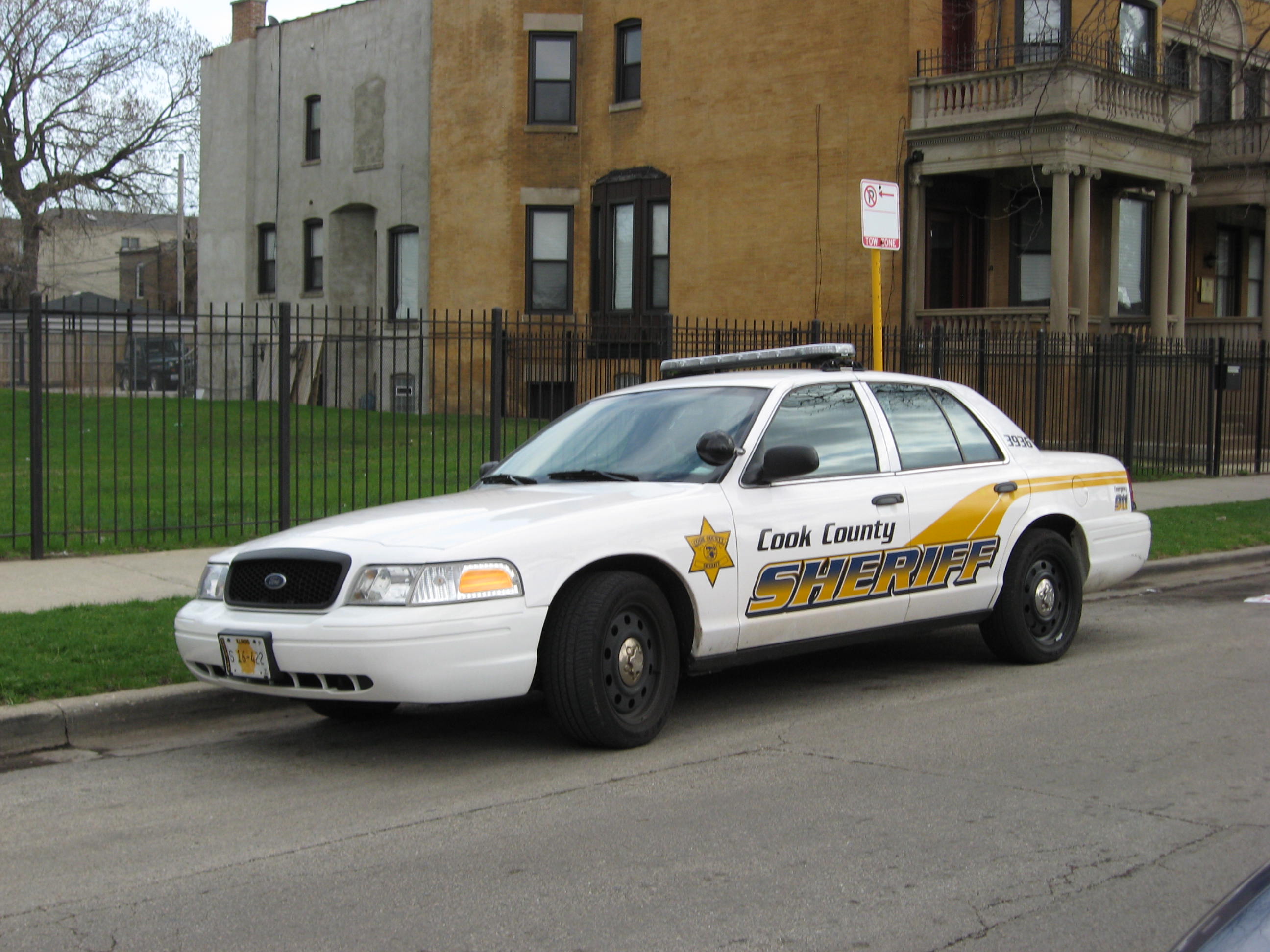 A white Cook County Sheriff's Office patrol car parked on a city street.