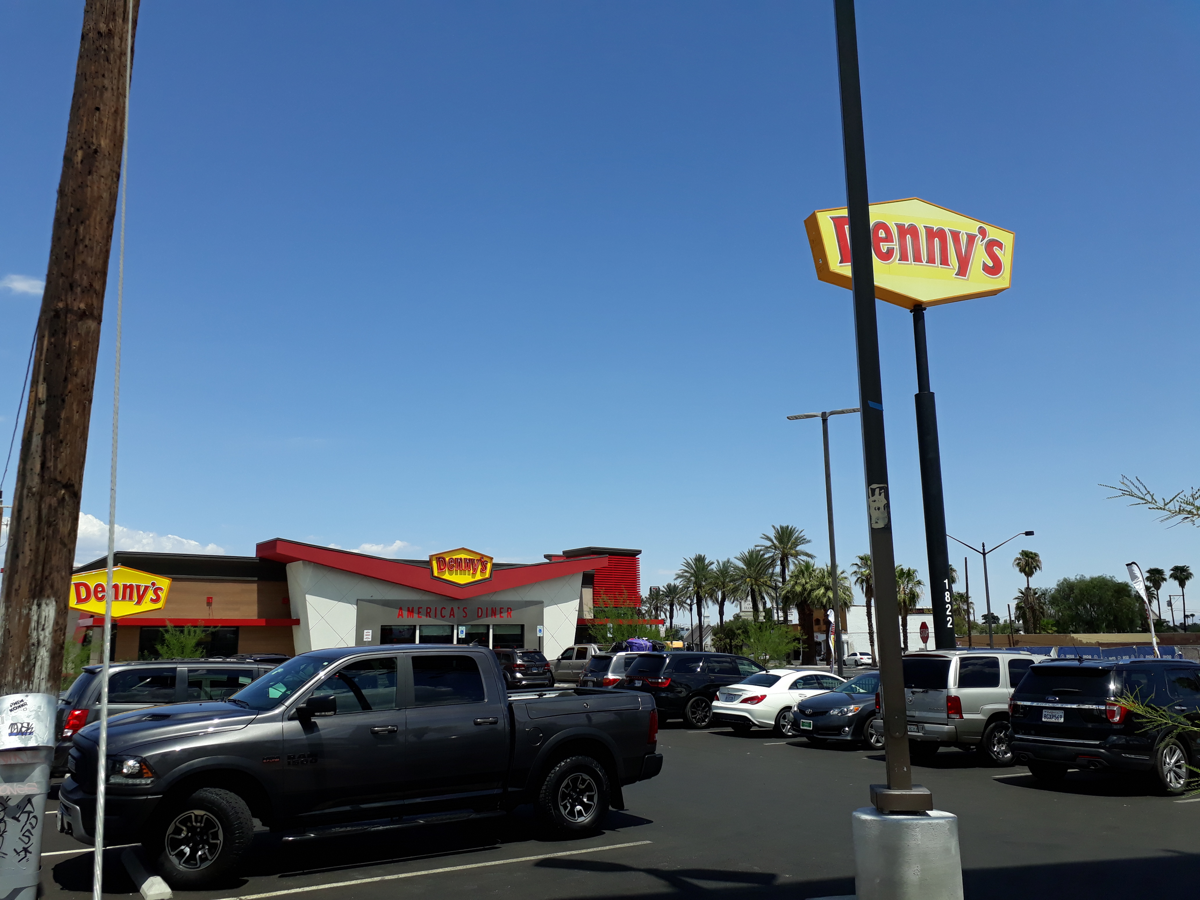 Denny's restaurant exterior with yellow and red pole sign and parking lot.