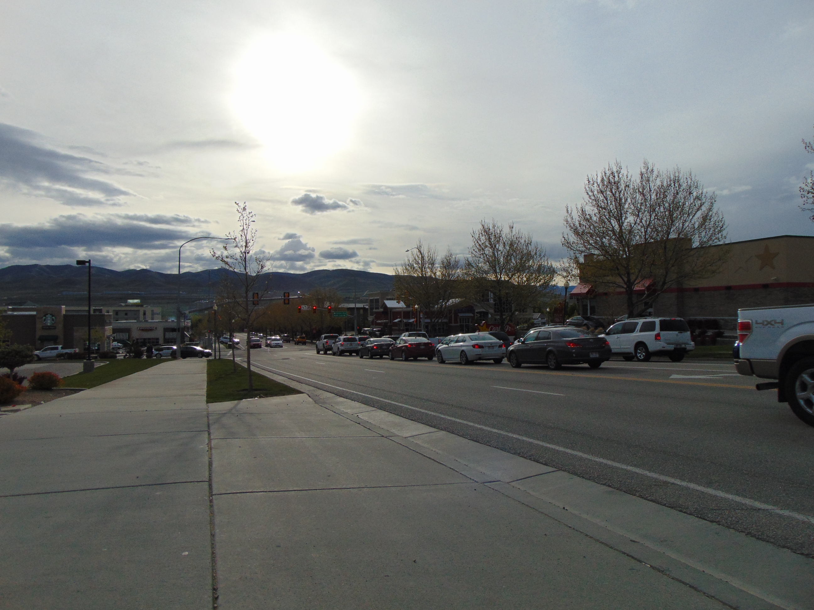 Multi-lane highway stretching east through Lehi, Utah, with mountains visible in the distance.