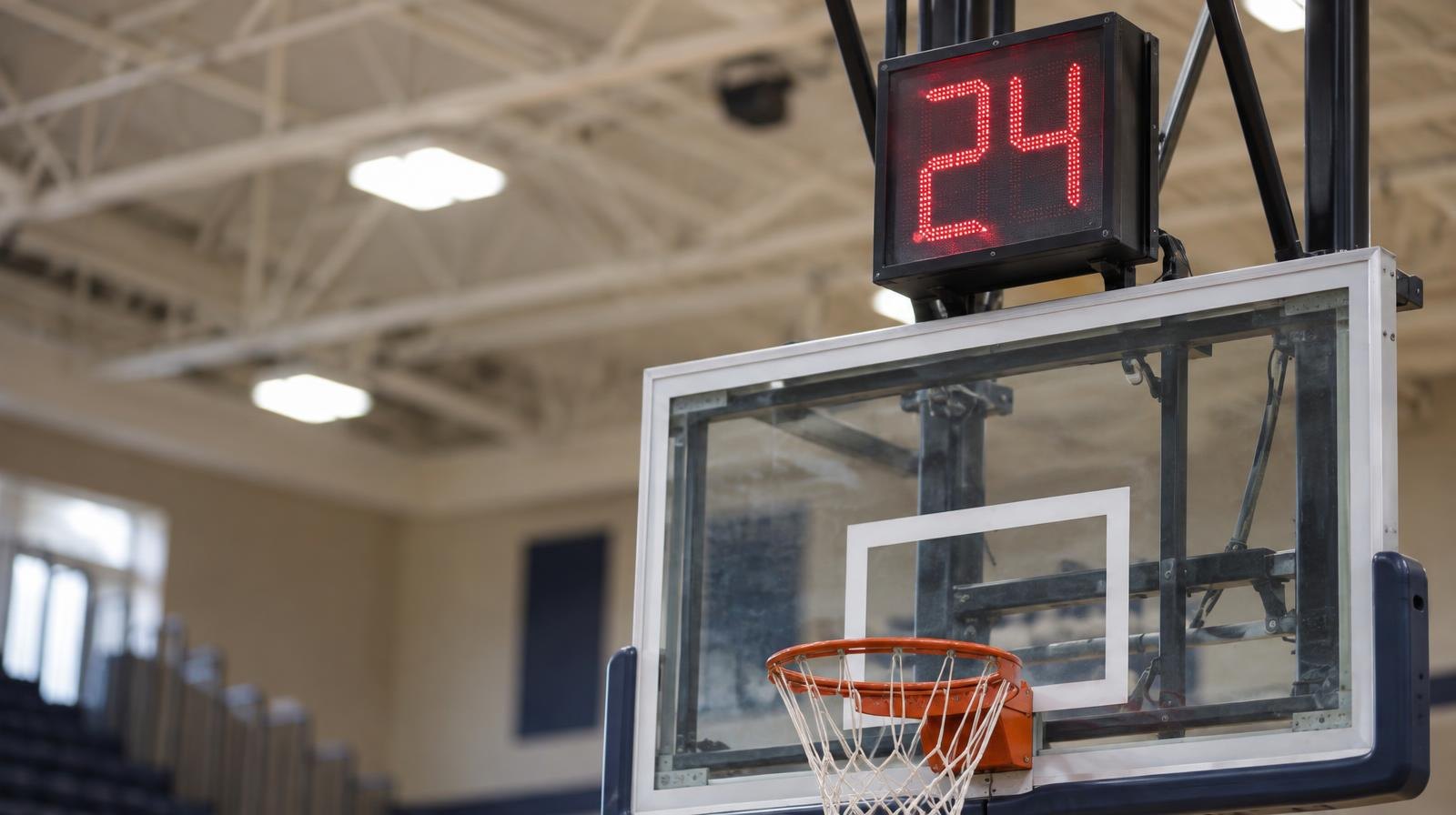 A shot clock display mounted above a basketball backboard in a gymnasium.