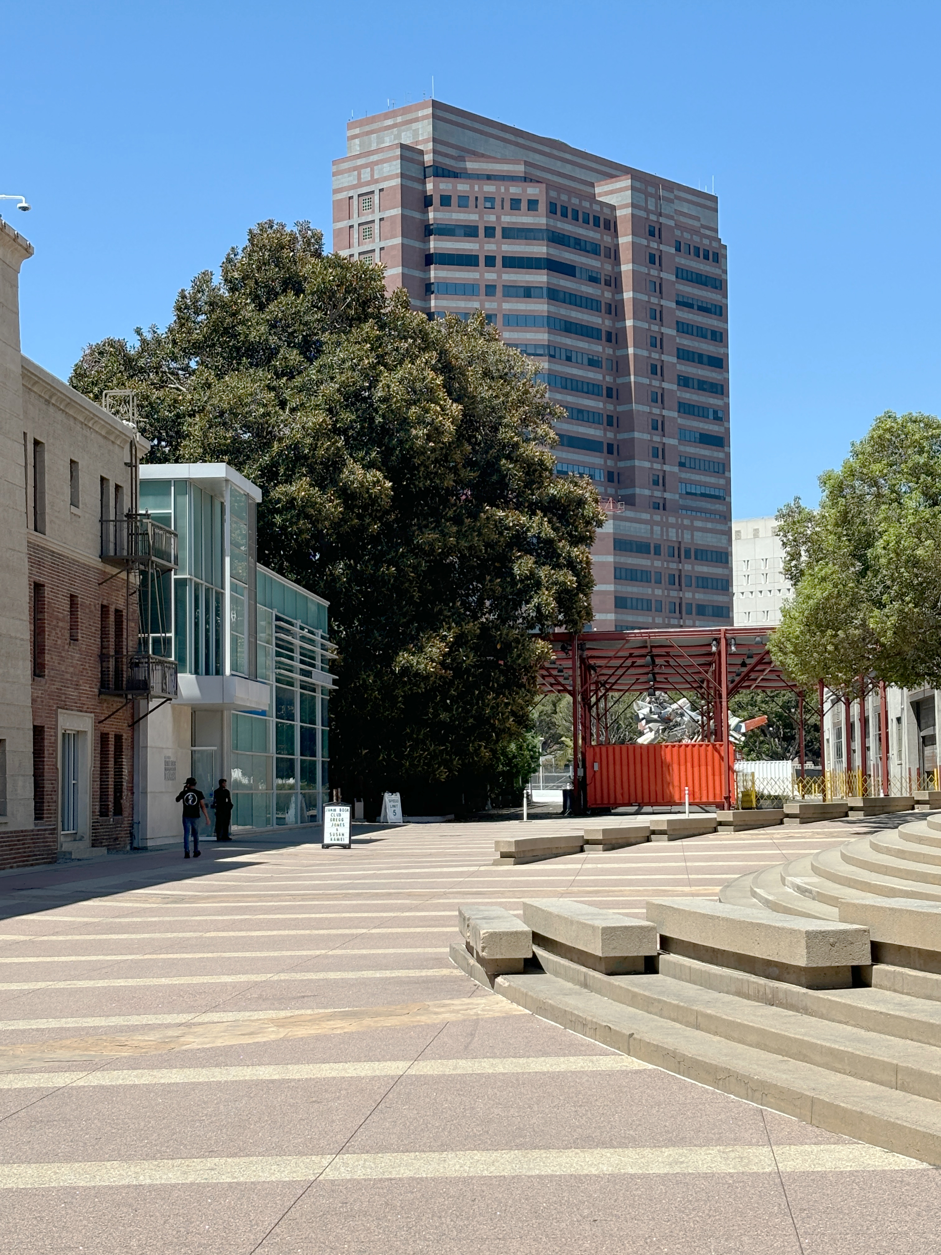 Exterior plaza and tall tower of a federal courthouse building under a clear blue sky.