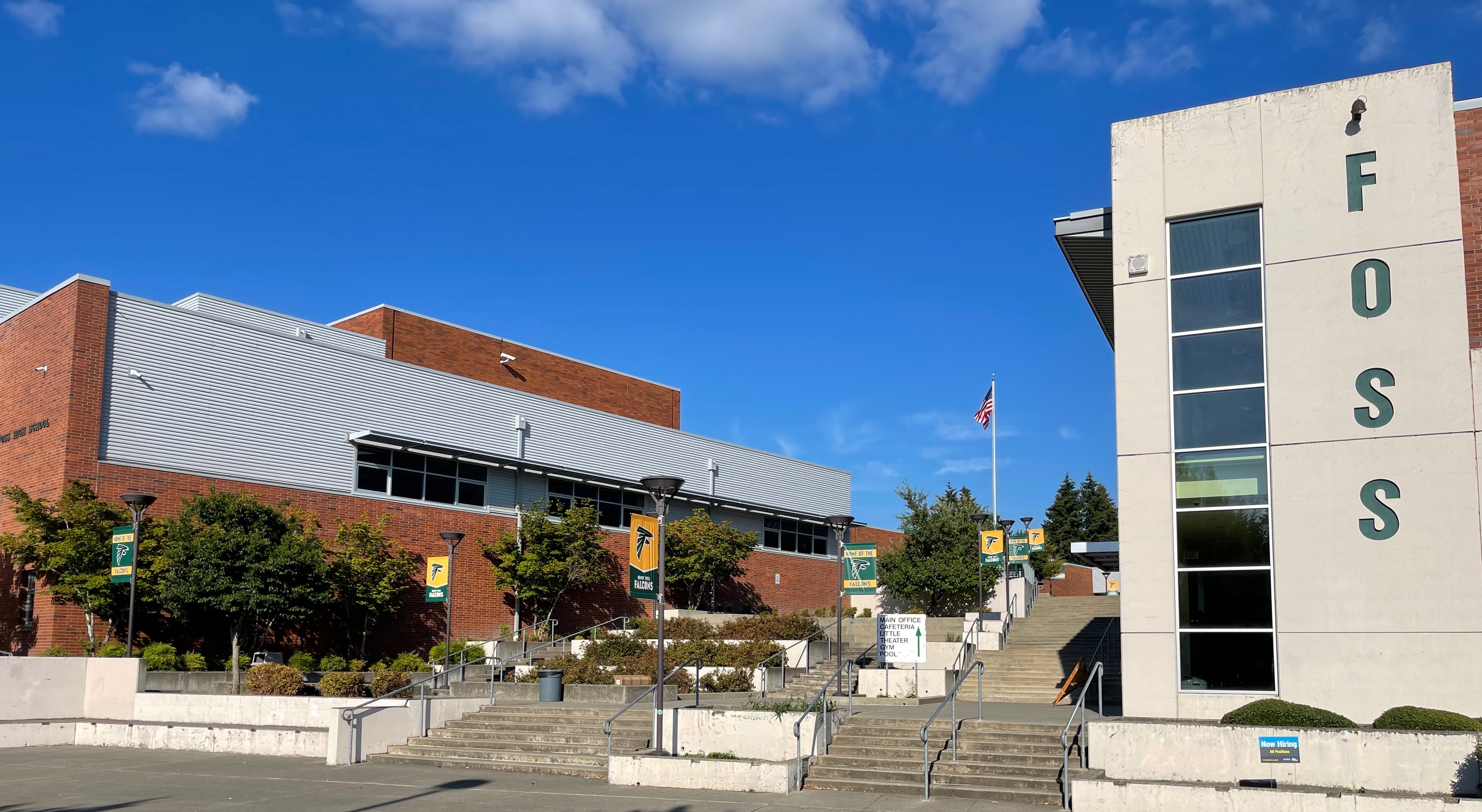 School building exterior with a tall concrete tower spelling F-O-S-S and a flagpole.