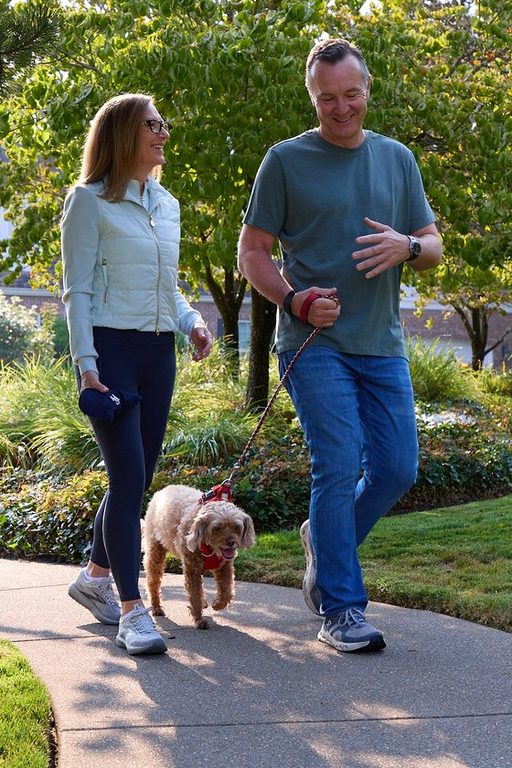 Neil and Claire Tunmore walking their dog along a Lake Oswego neighborhood path