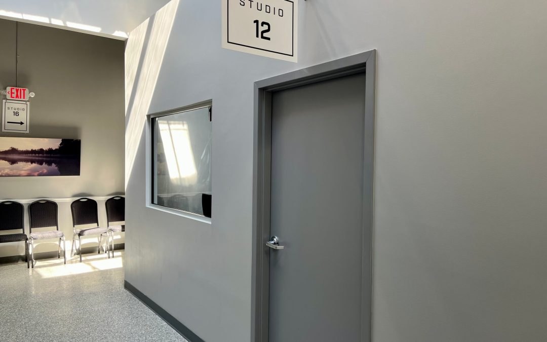 Interior hallway with a numbered studio door labeled Studio 12 in a converted warehouse building.