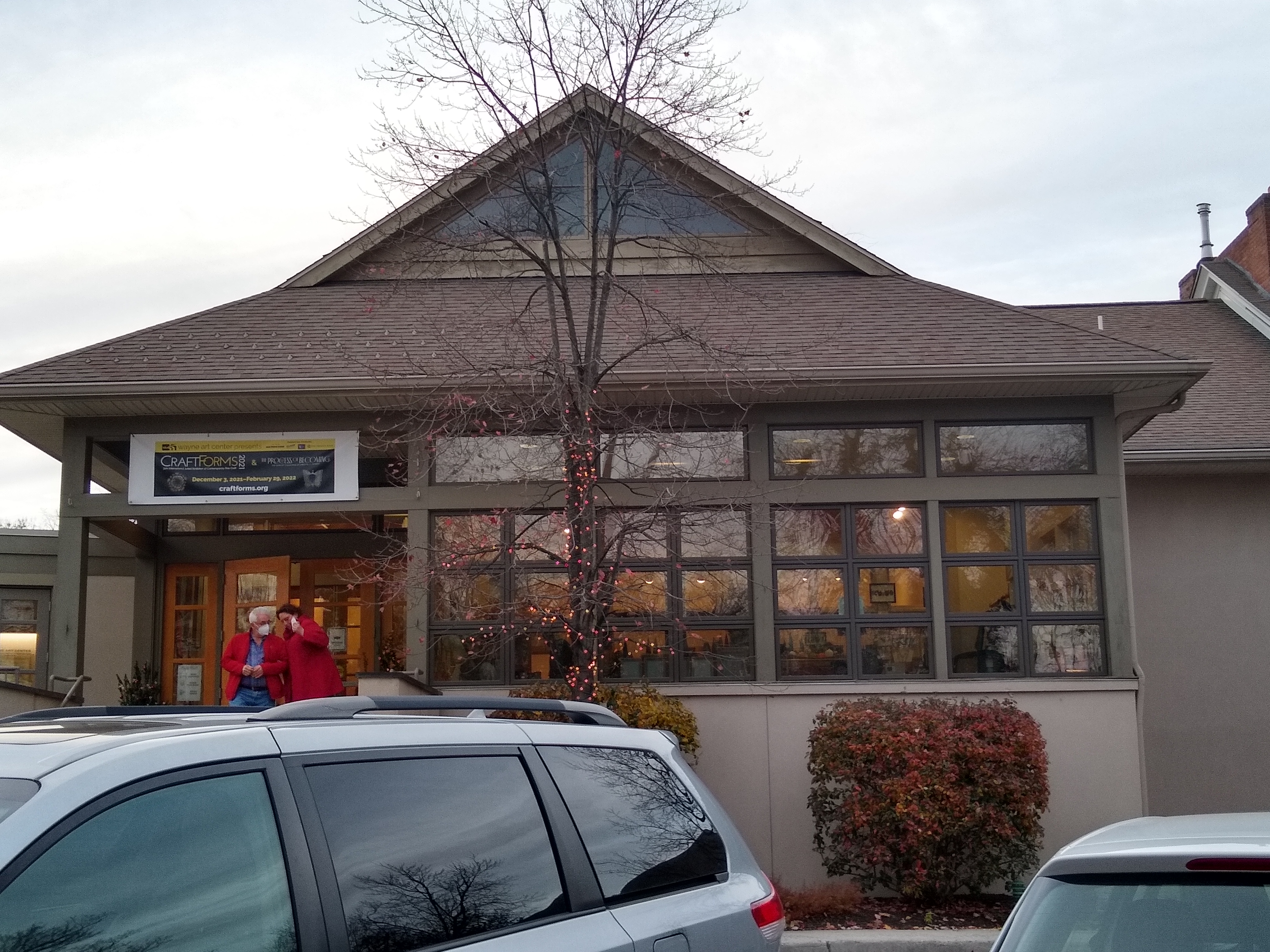 Exterior of a building with a gabled roof and a sign reading Wayne Art Center.