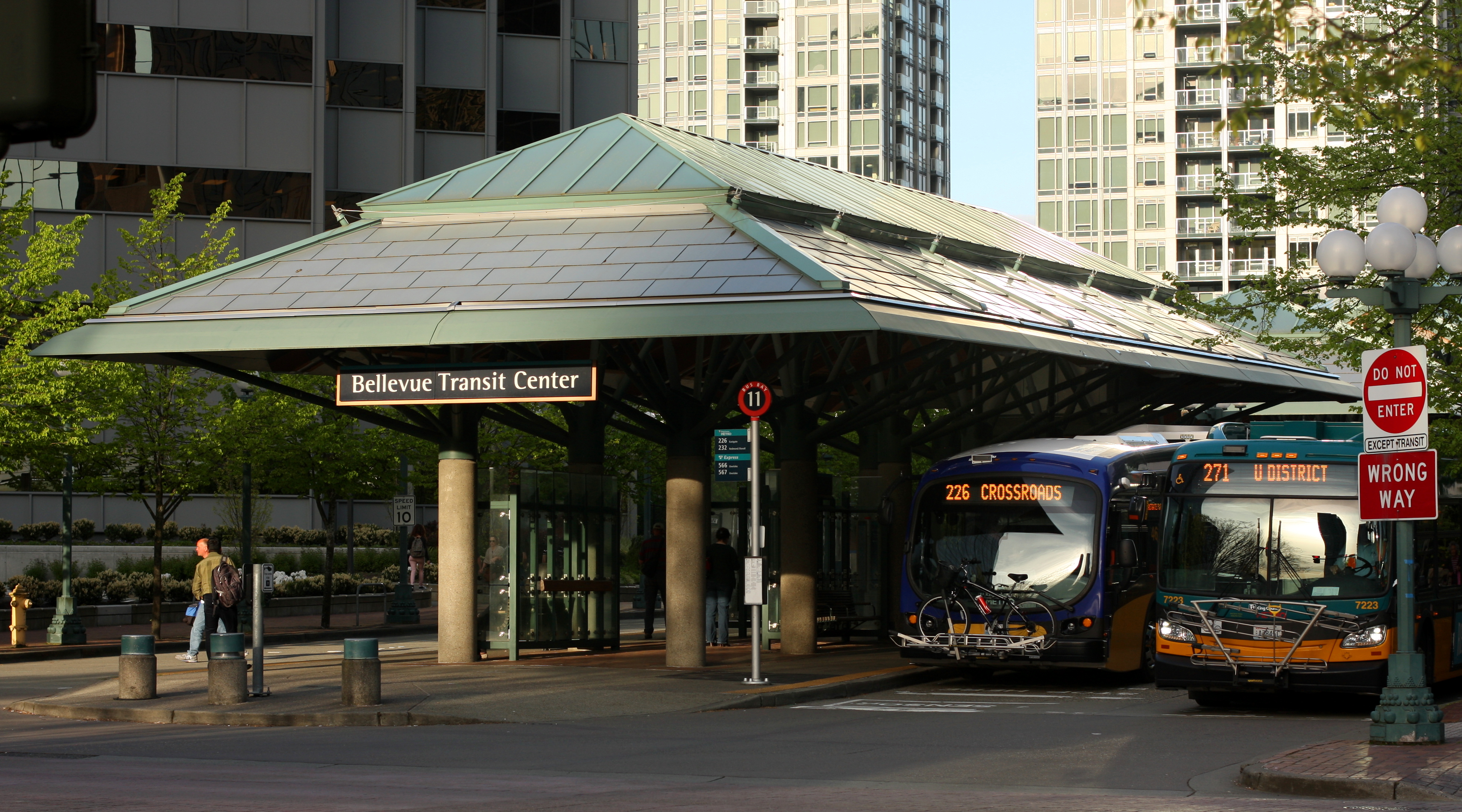 Exterior of Bellevue Transit Center with green roof canopy and Metro buses parked underneath.