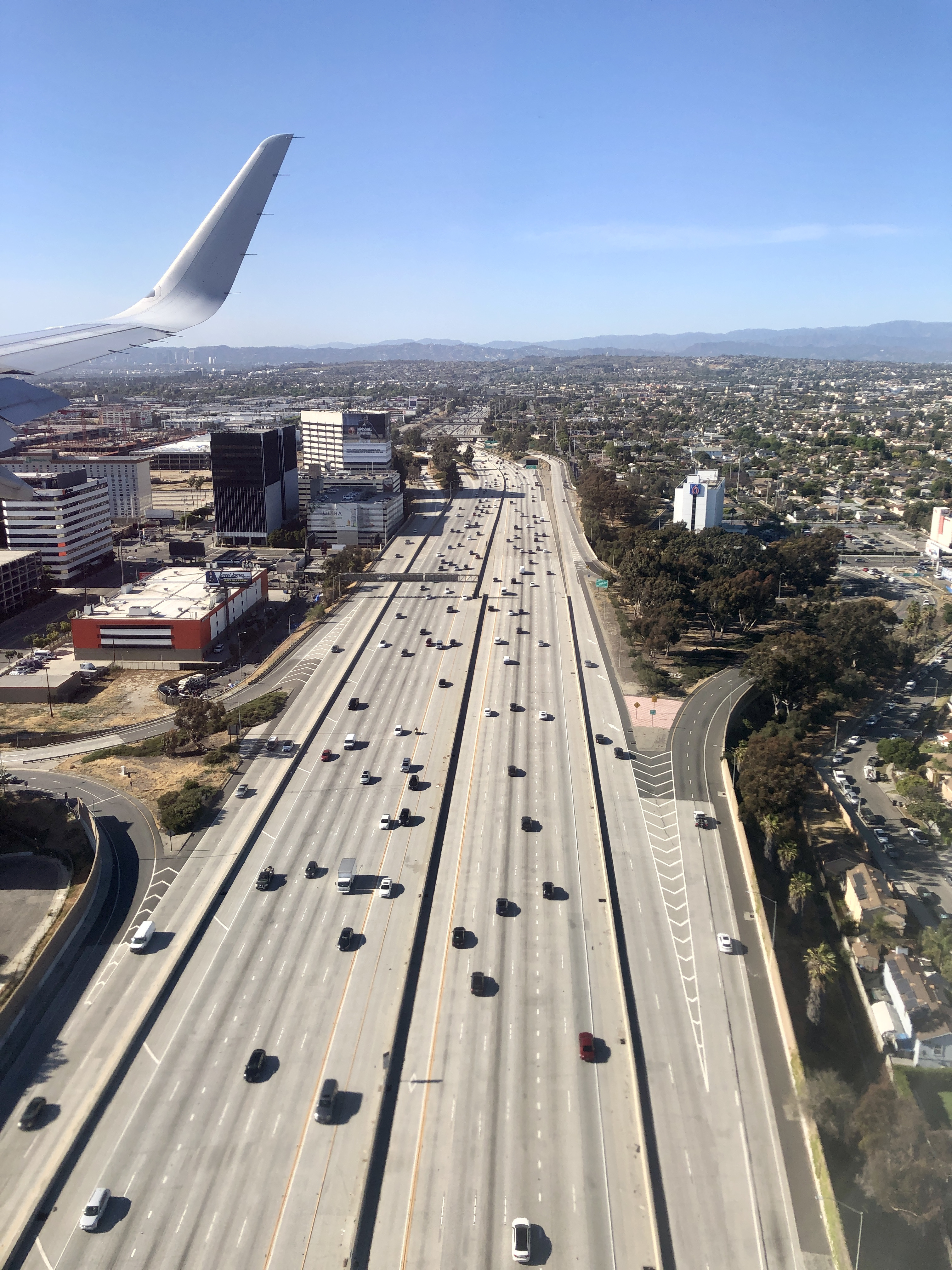 Aerial view of the 405 Freeway with multiple lanes of traffic through a dense urban area.