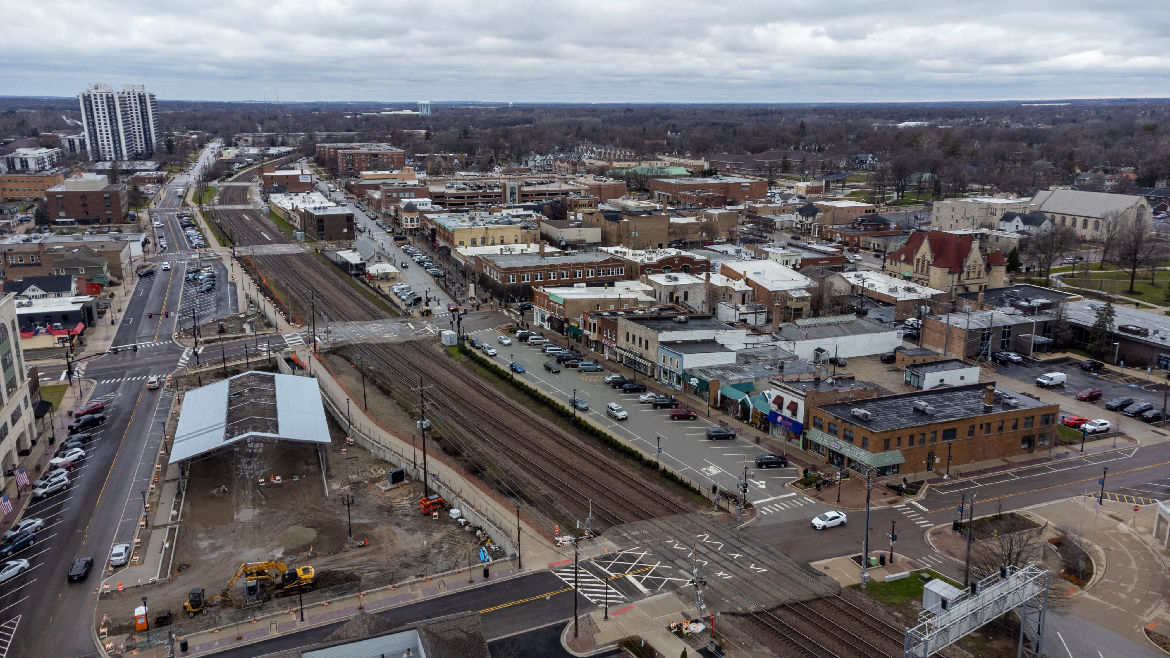 Aerial drone view of downtown Wheaton, Illinois, showing railroad tracks and buildings.