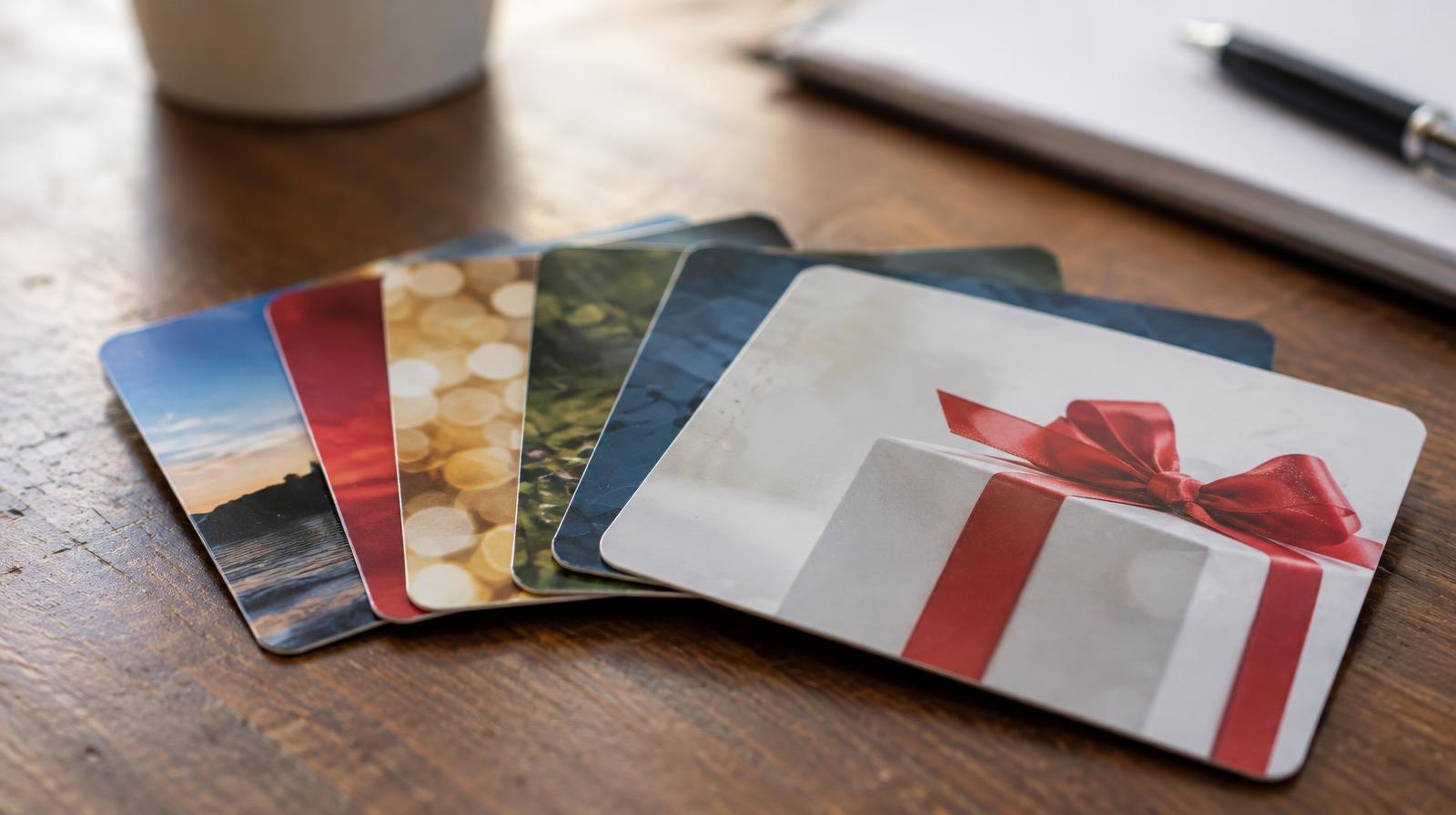 Several retail gift cards fanned out on a flat surface.