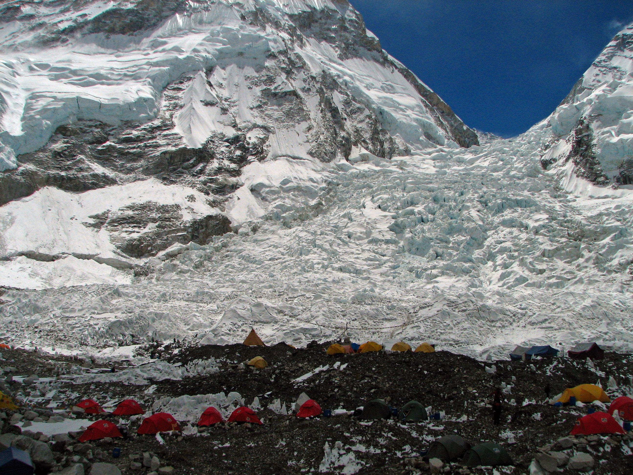 Colorful expedition tents at Everest Base Camp with the Khumbu Icefall rising steeply behind.