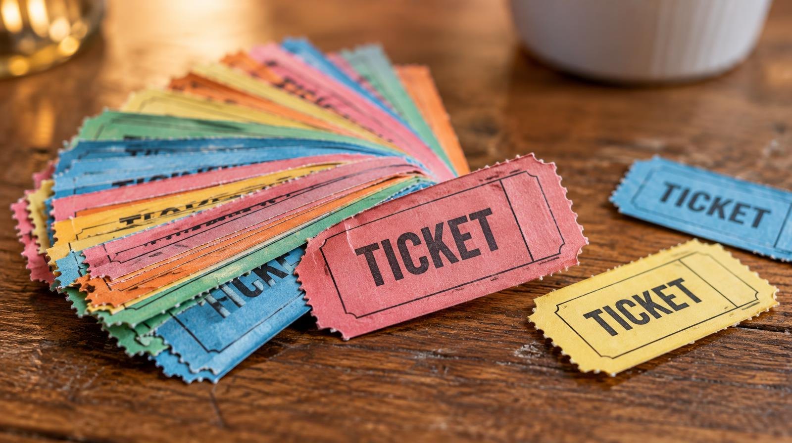 A fan of colorful raffle tickets spread on a wooden surface.