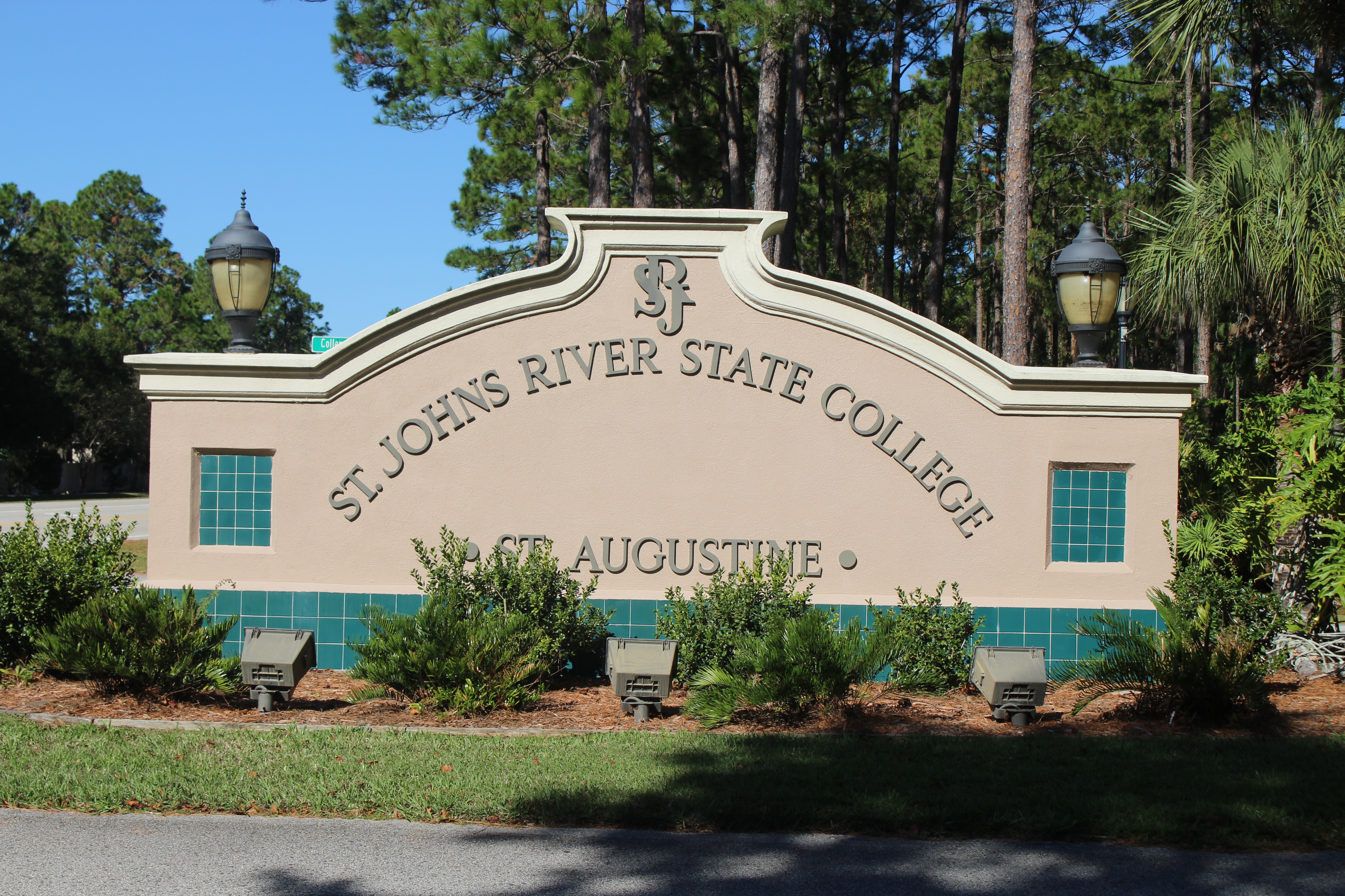 Stone entrance monument sign for St. Johns River State College flanked by decorative lamp posts.