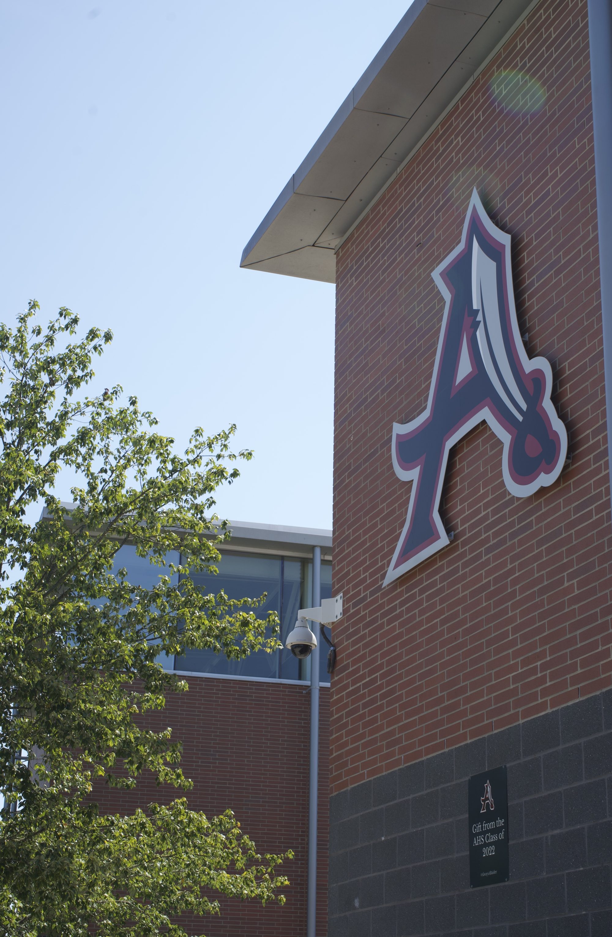 Brick school building exterior with large stylized letter A logo on wall.