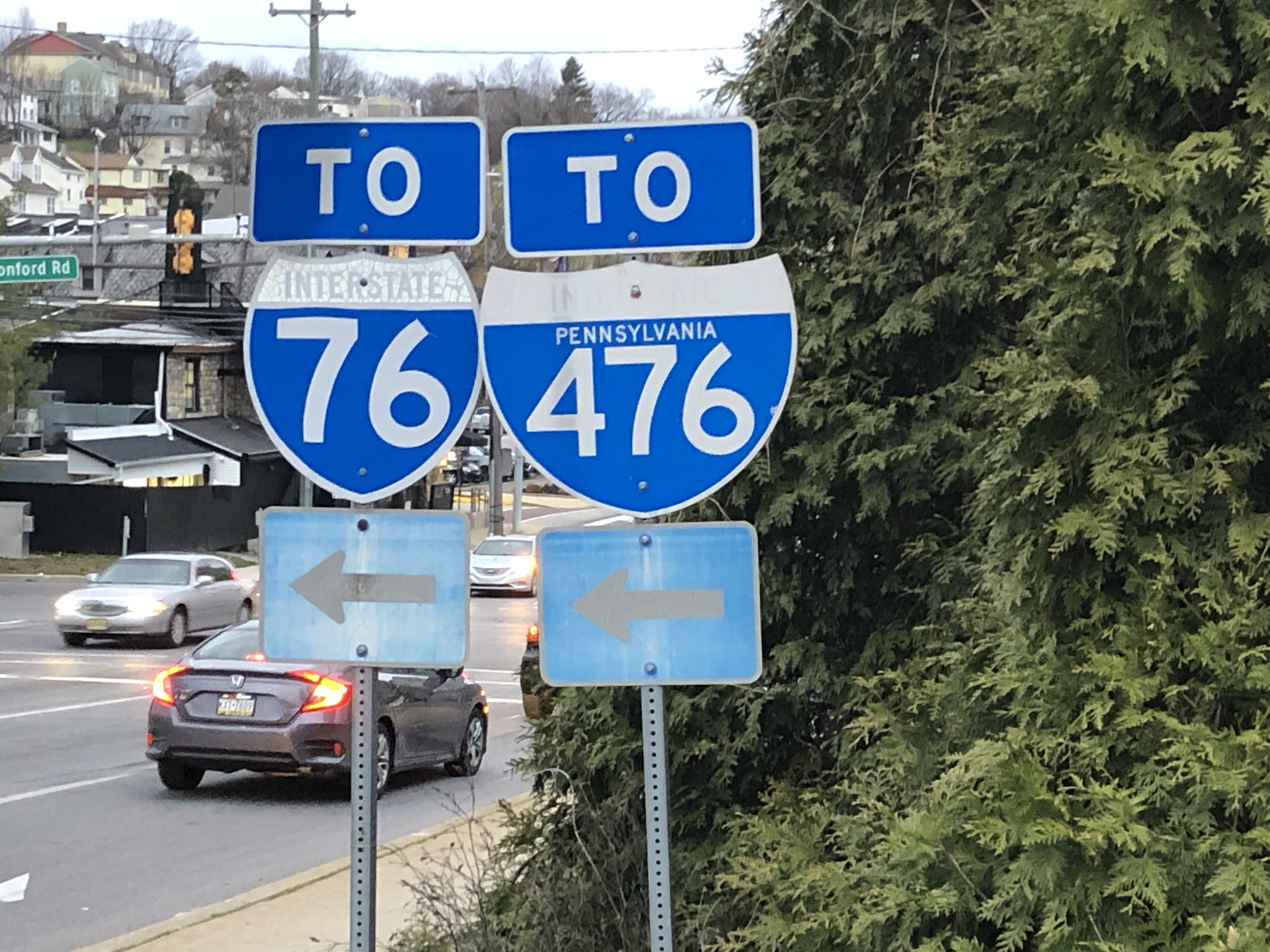 Green highway signs pointing left toward Interstate 76 and Route 476.