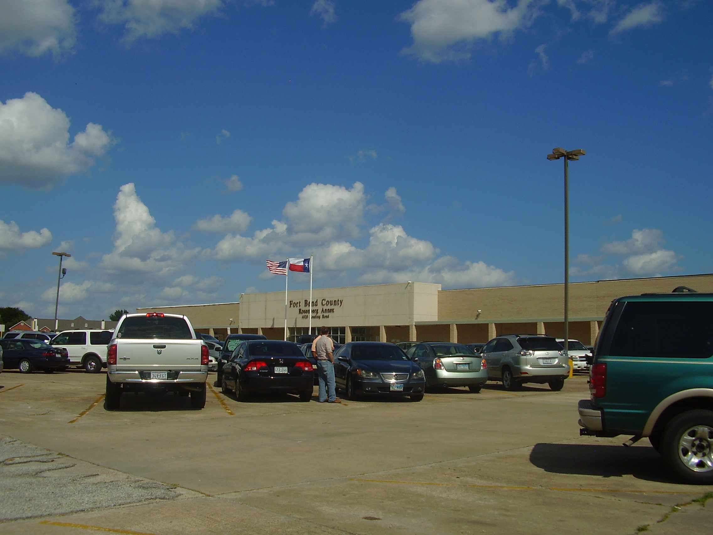Single-story government building labeled Fort Bend County with flags out front.