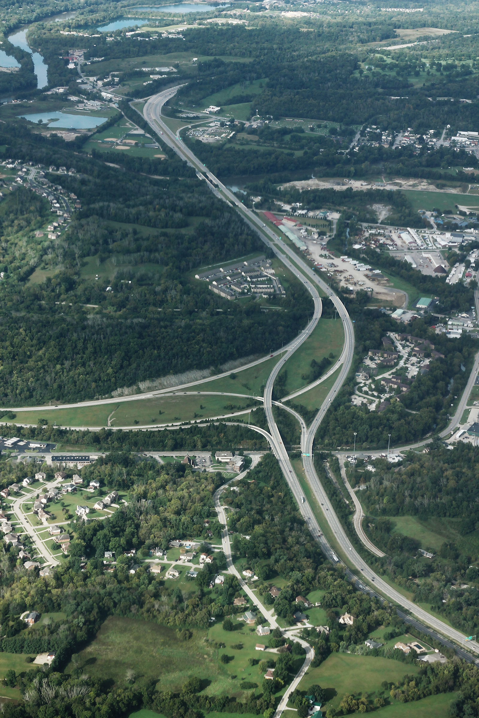 Aerial photo of two interstate highways converging through wooded suburban terrain.