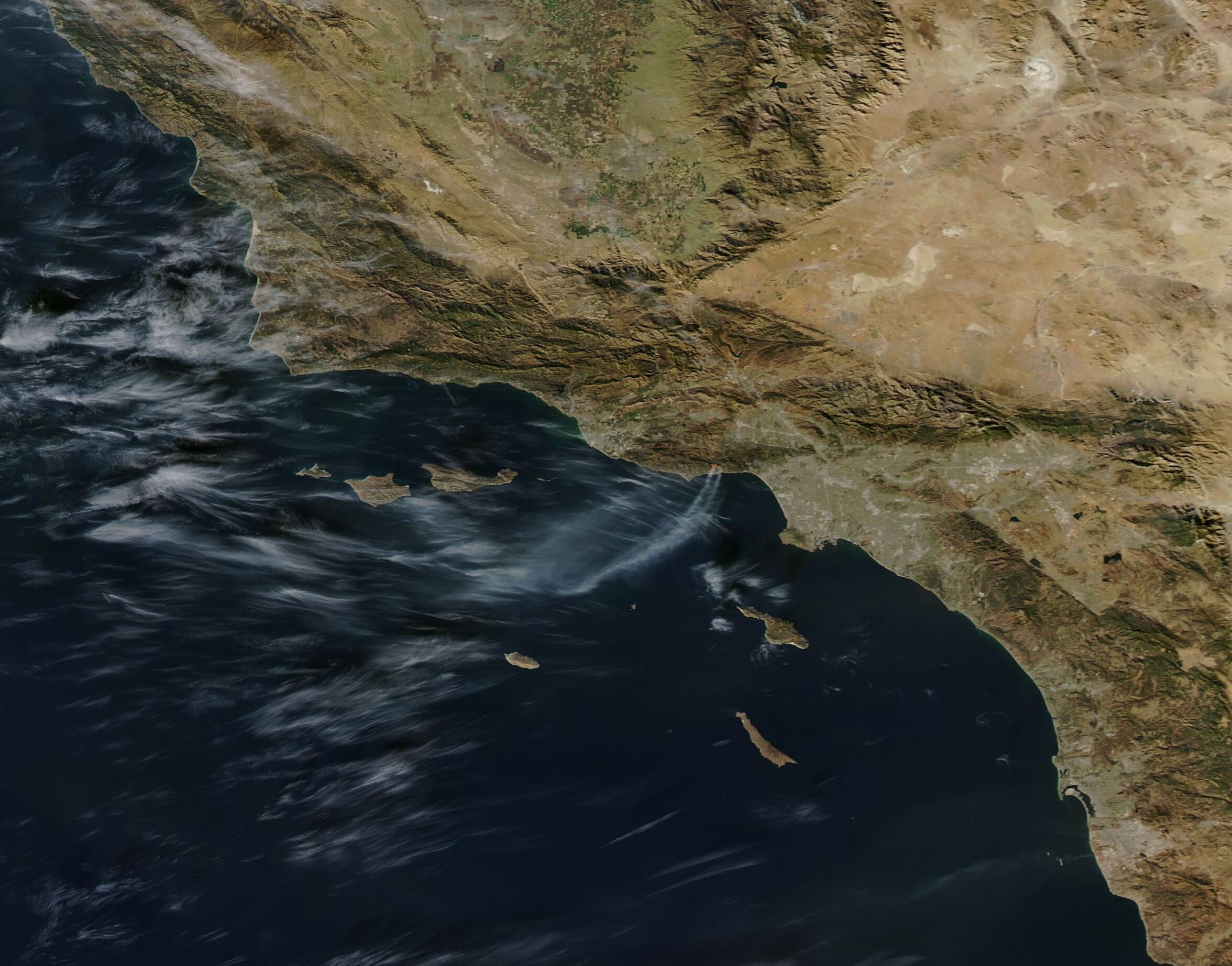 Satellite image showing wildfire smoke drifting over the Pacific Ocean from the Southern California coast.