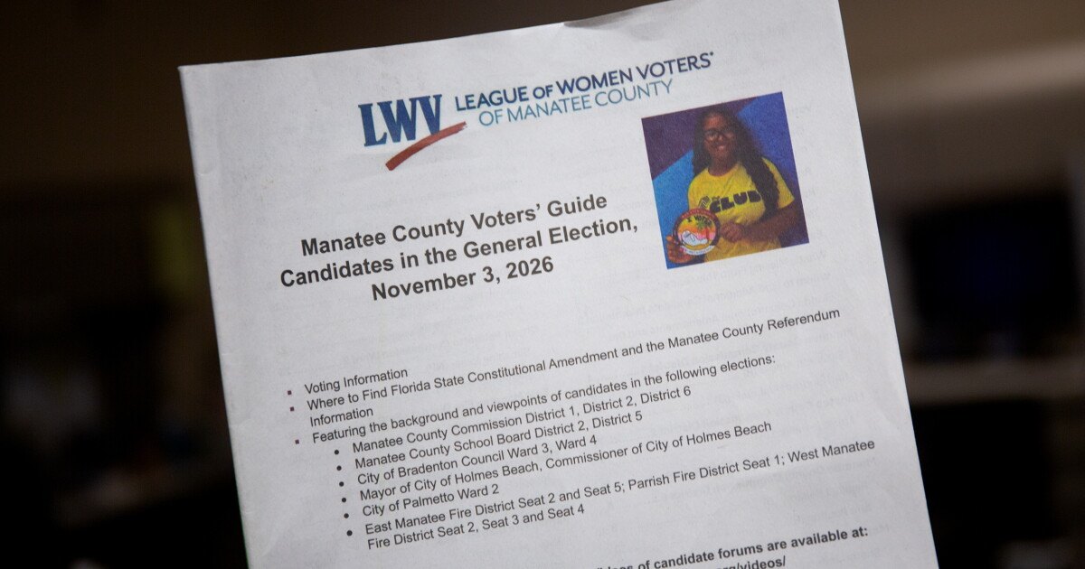 Close-up of a printed voter guide booklet with election candidate information on the cover.