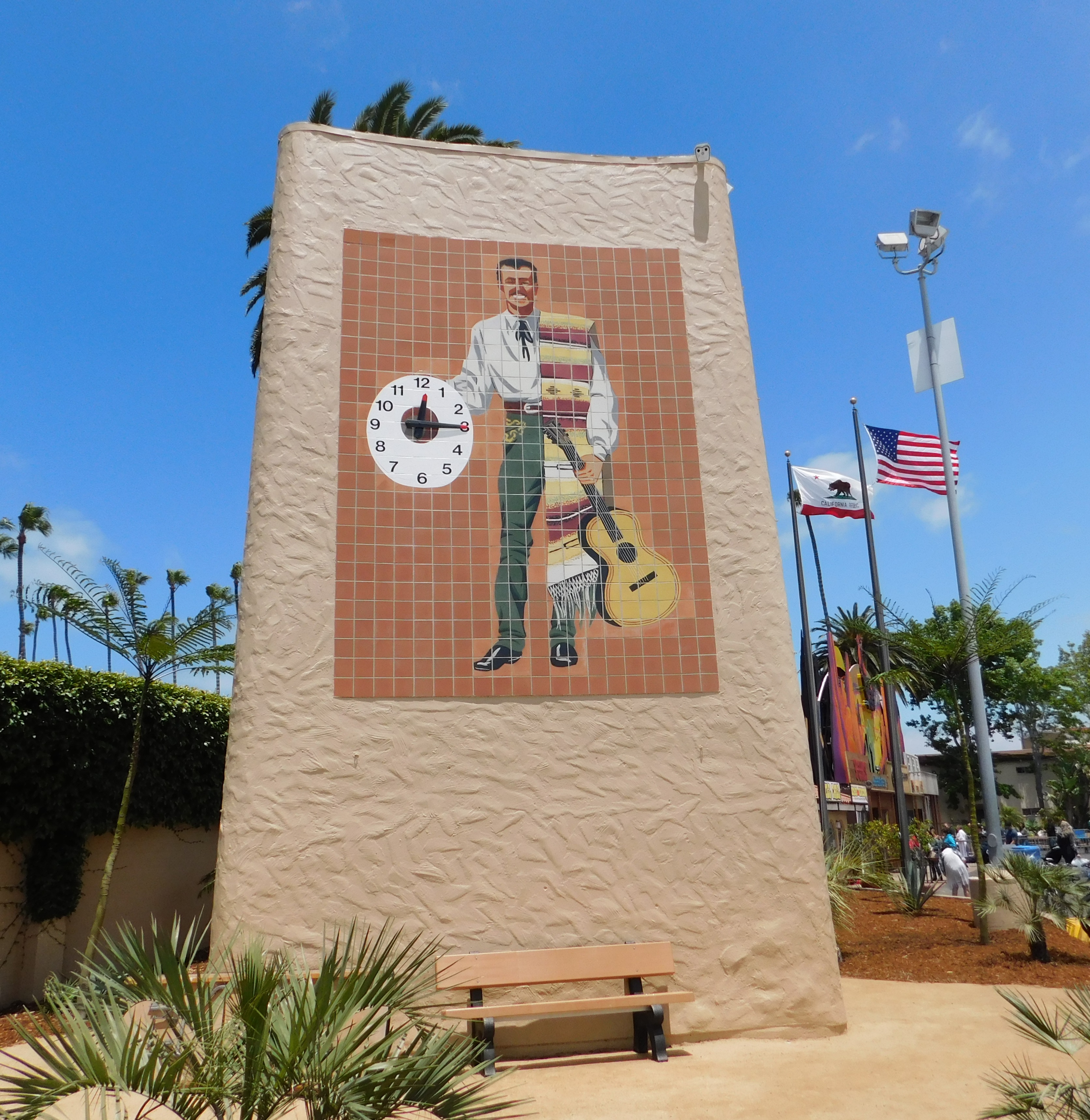 Mosaic tile tower with a caballero figure and clock face at a fairgrounds.