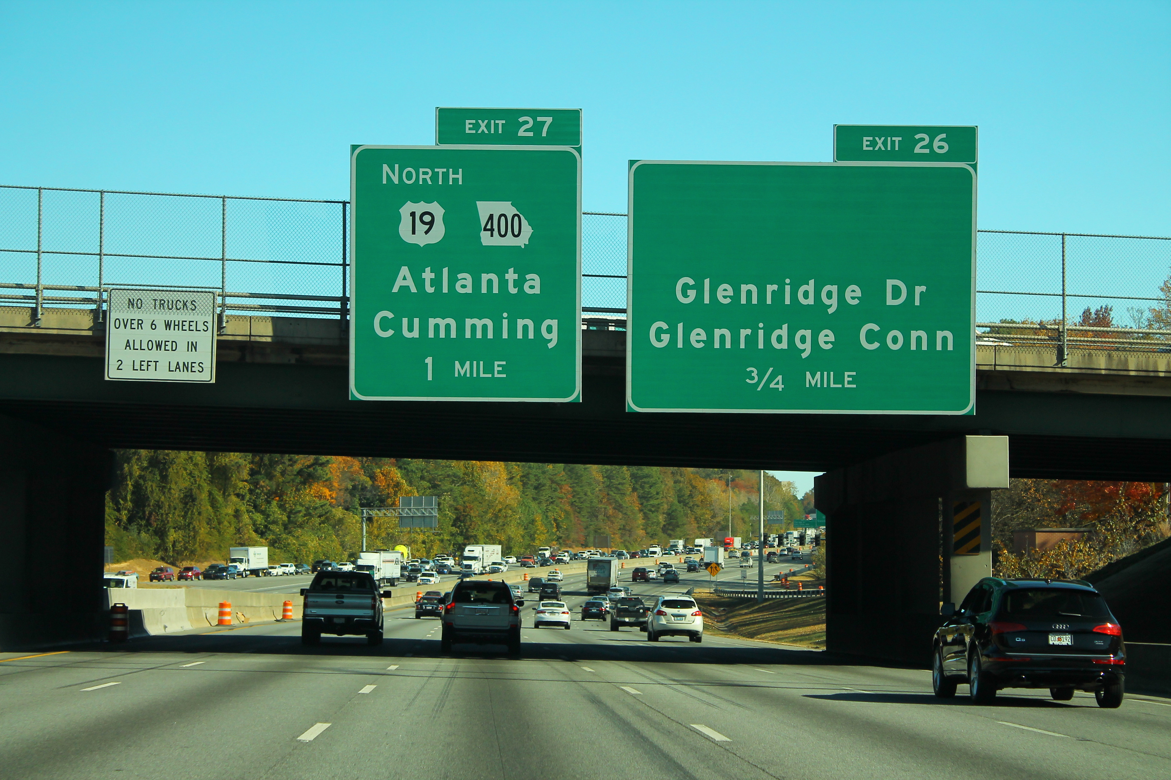 Multi-lane Georgia 400 highway with green overhead exit signs and moving traffic.