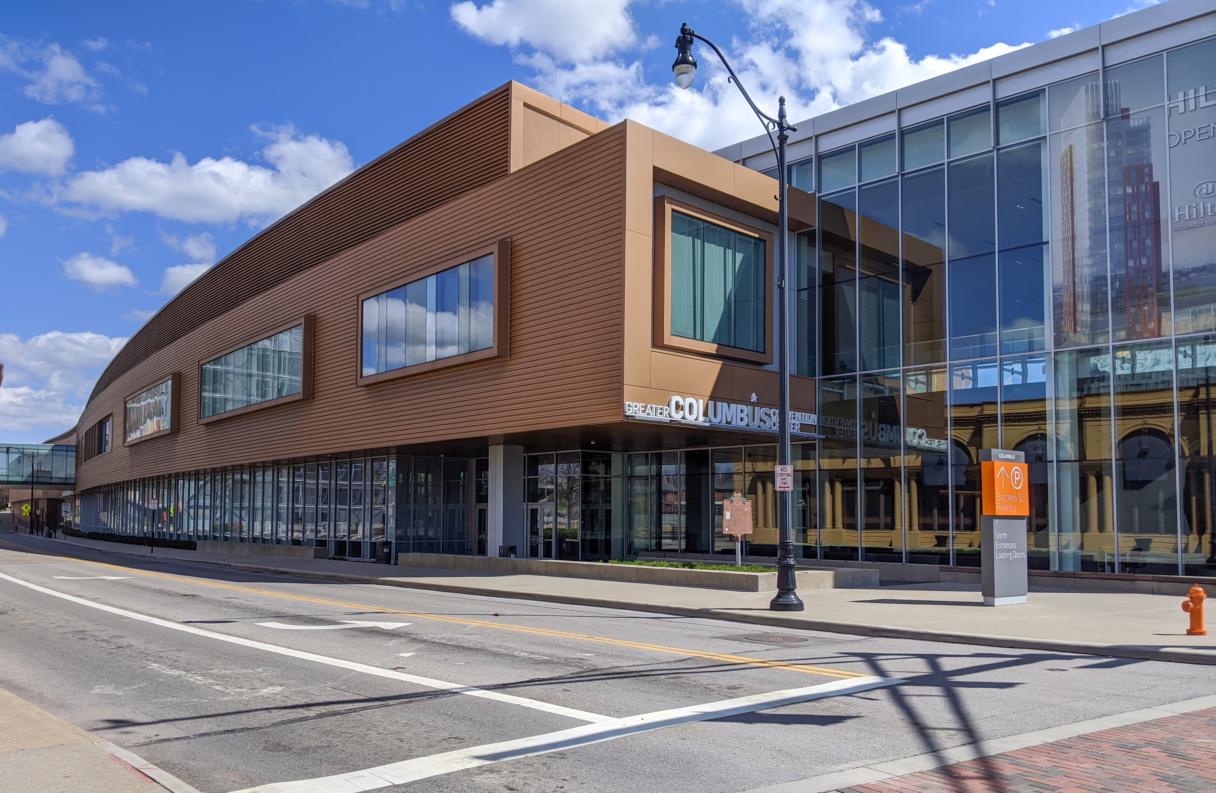 Modern convention center building with curved copper cladding and large glass windows.