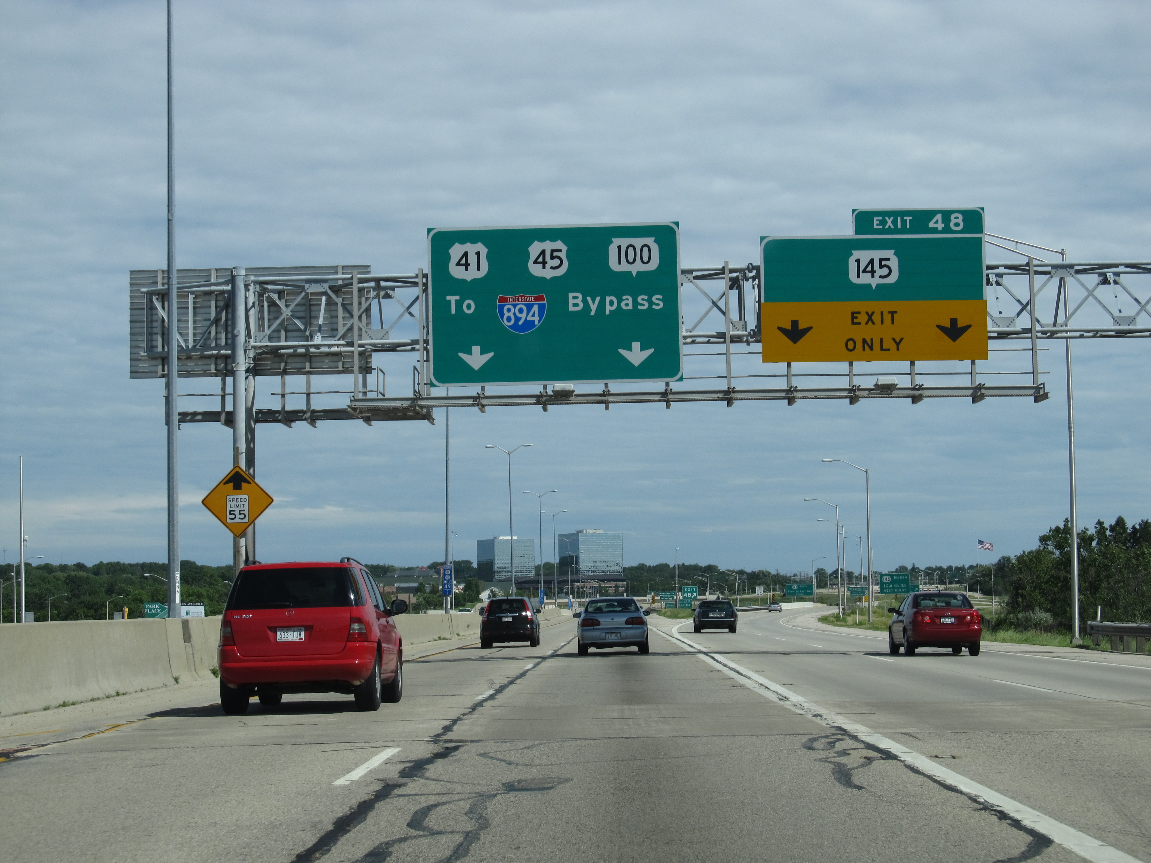 Overhead green highway signs for U.S. Route 41 on a busy multi-lane freeway.