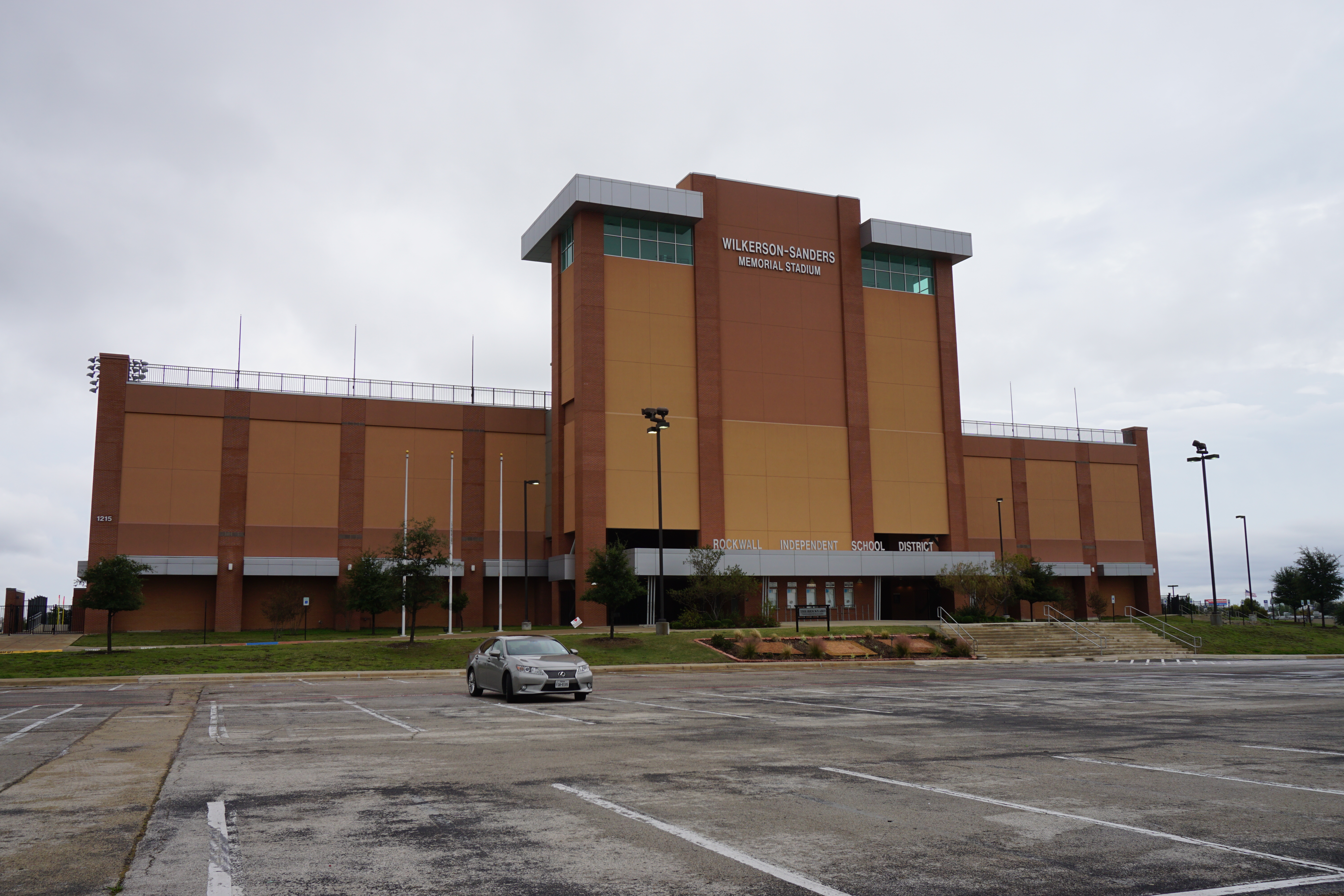 Brick exterior of a large high school football stadium under an overcast sky.