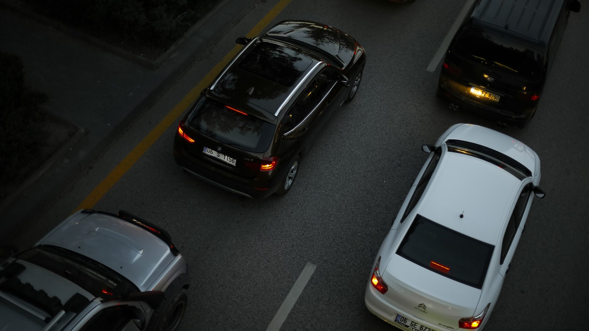 Aerial shot showing multiple cars driving on a city road during the evening, illustrating urban traffic.