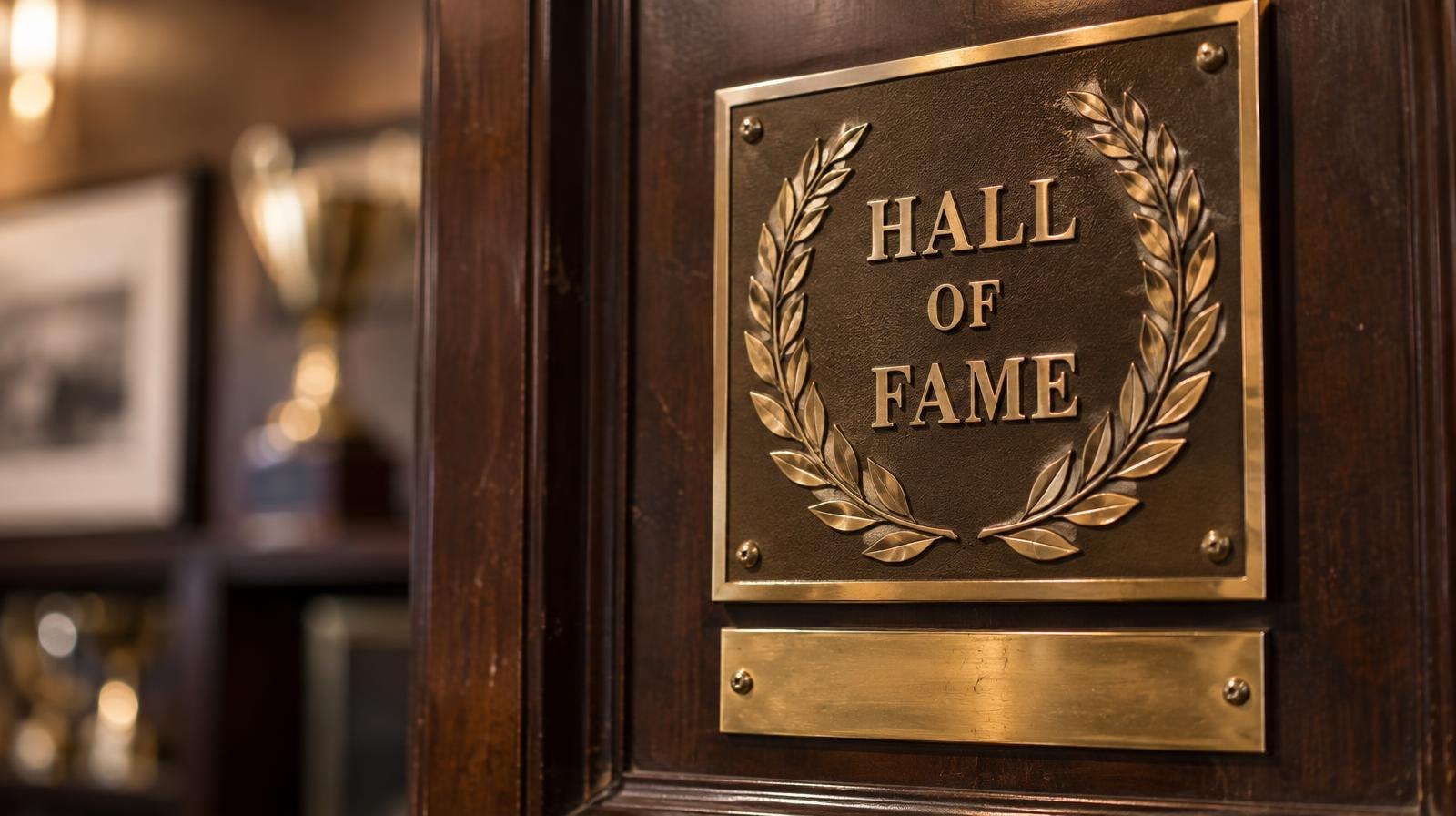 Gold Hall of Fame plaque on a dark wooden board with an engraved nameplate.