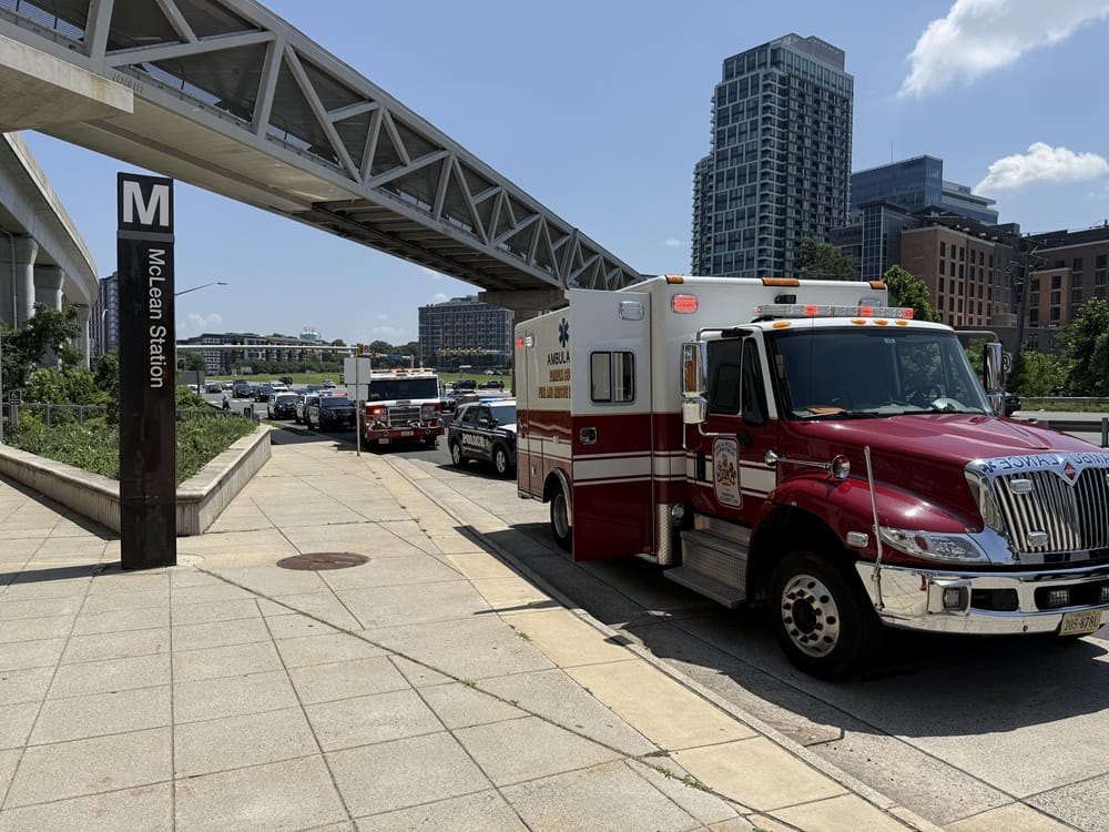 Ambulance parked near the McLean Metro station sign with high-rise buildings in the background.