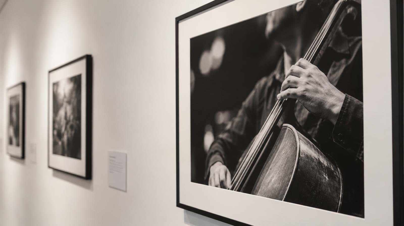 A framed black-and-white portrait photograph of a musician hanging on a white gallery wall.