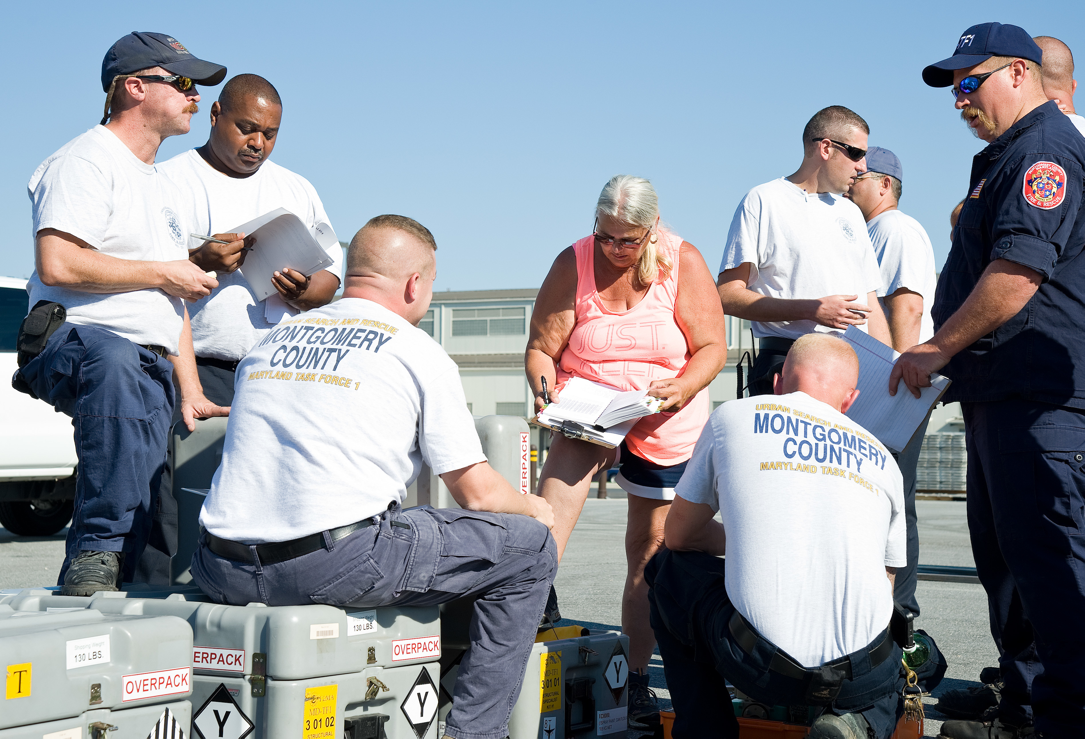 People wearing Montgomery County Urban Search and Rescue Team shirts review documents outdoors.