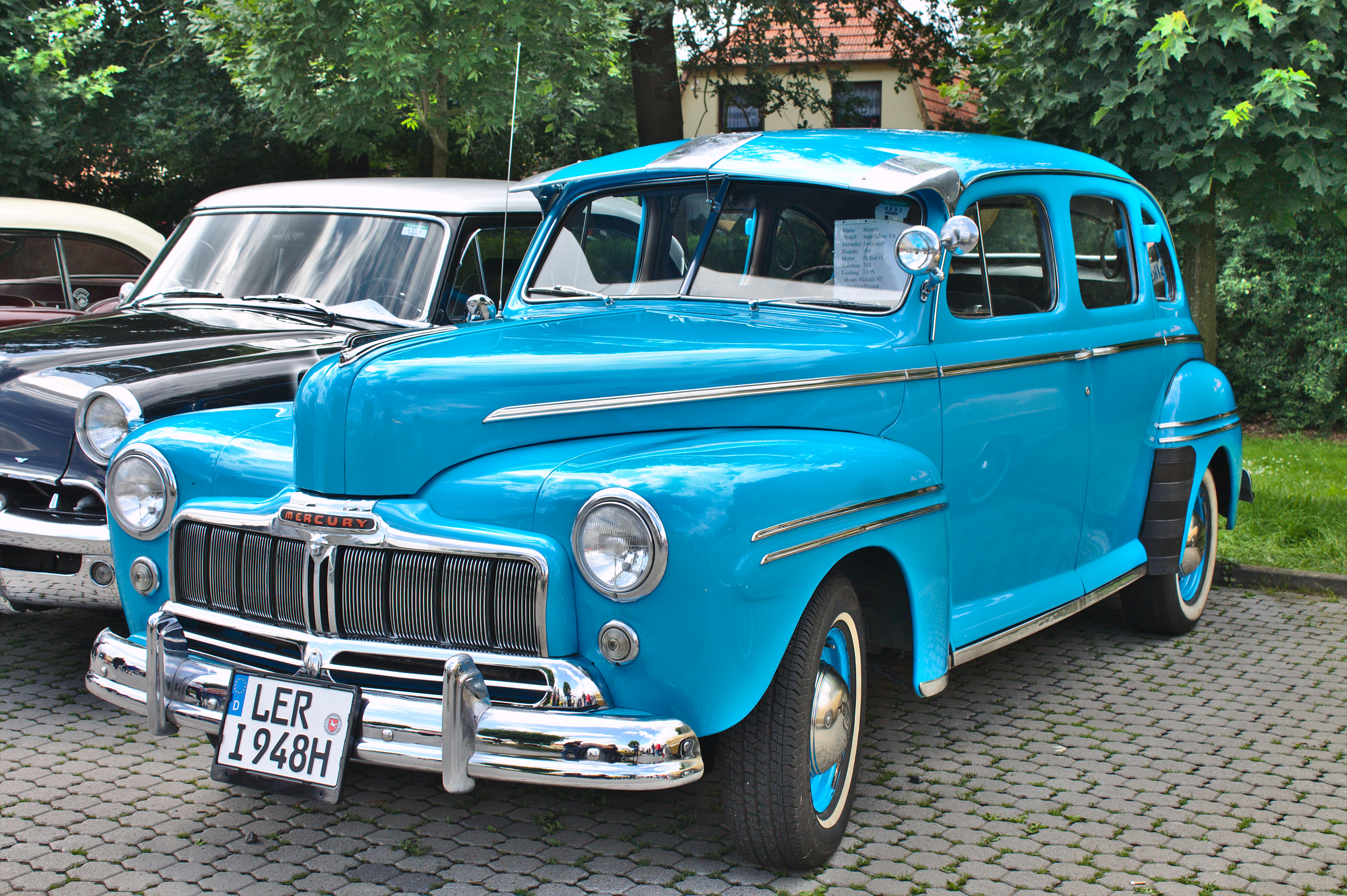 A bright blue 1942 Mercury Eight classic car on display at an outdoor car show.