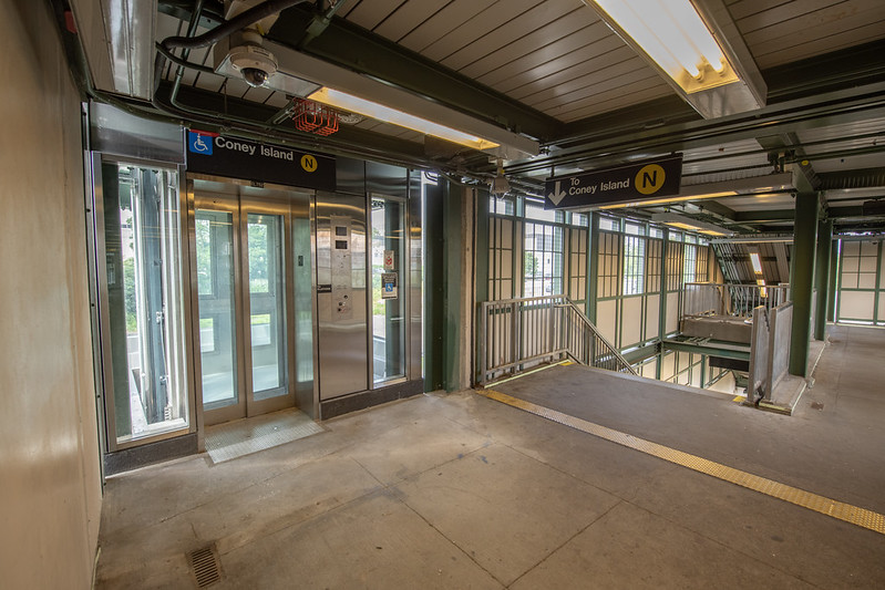 Transit station interior showing ADA elevator doors and a wheelchair accessibility symbol.