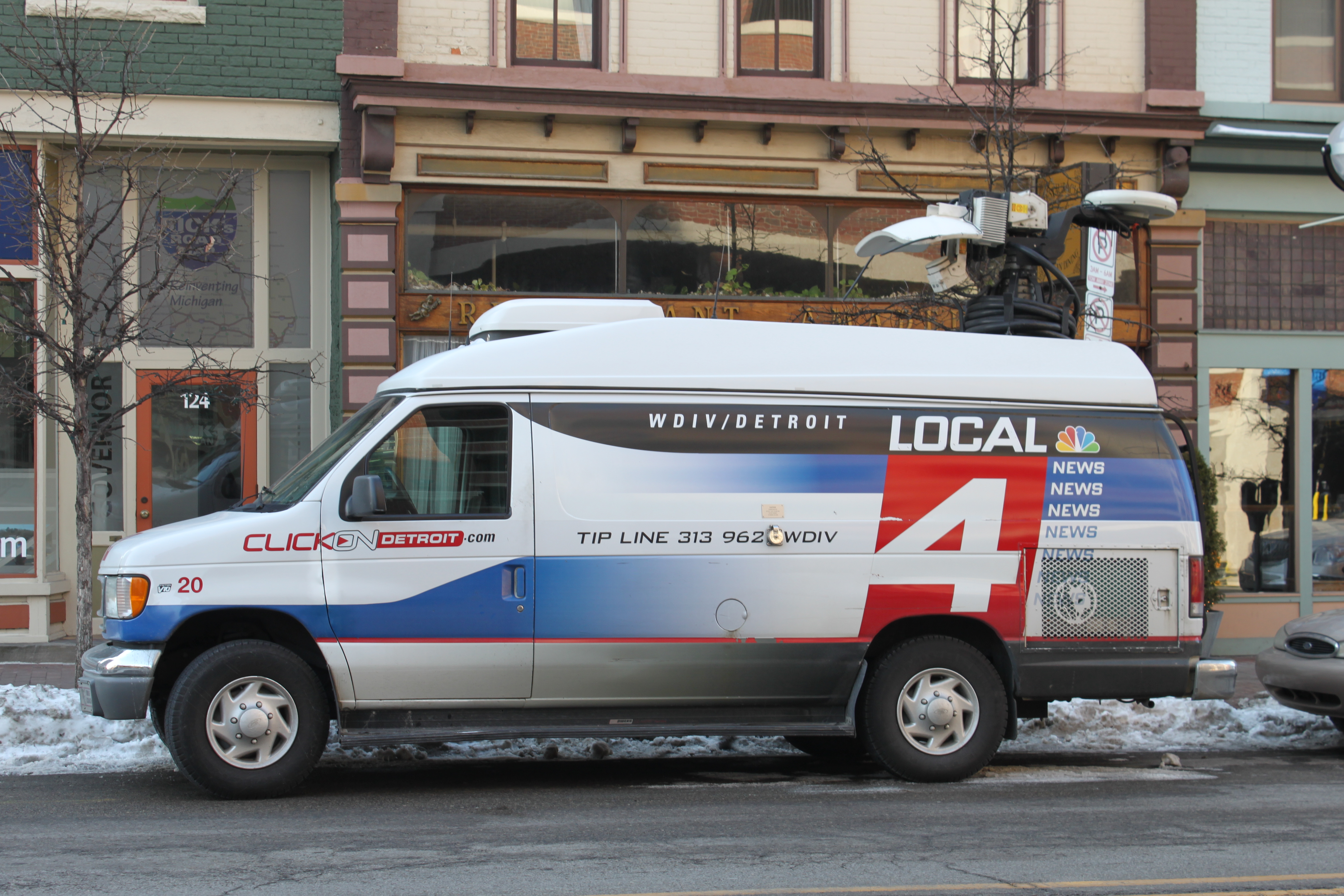 A white news van with WDIV Local 4 branding parked outdoors.