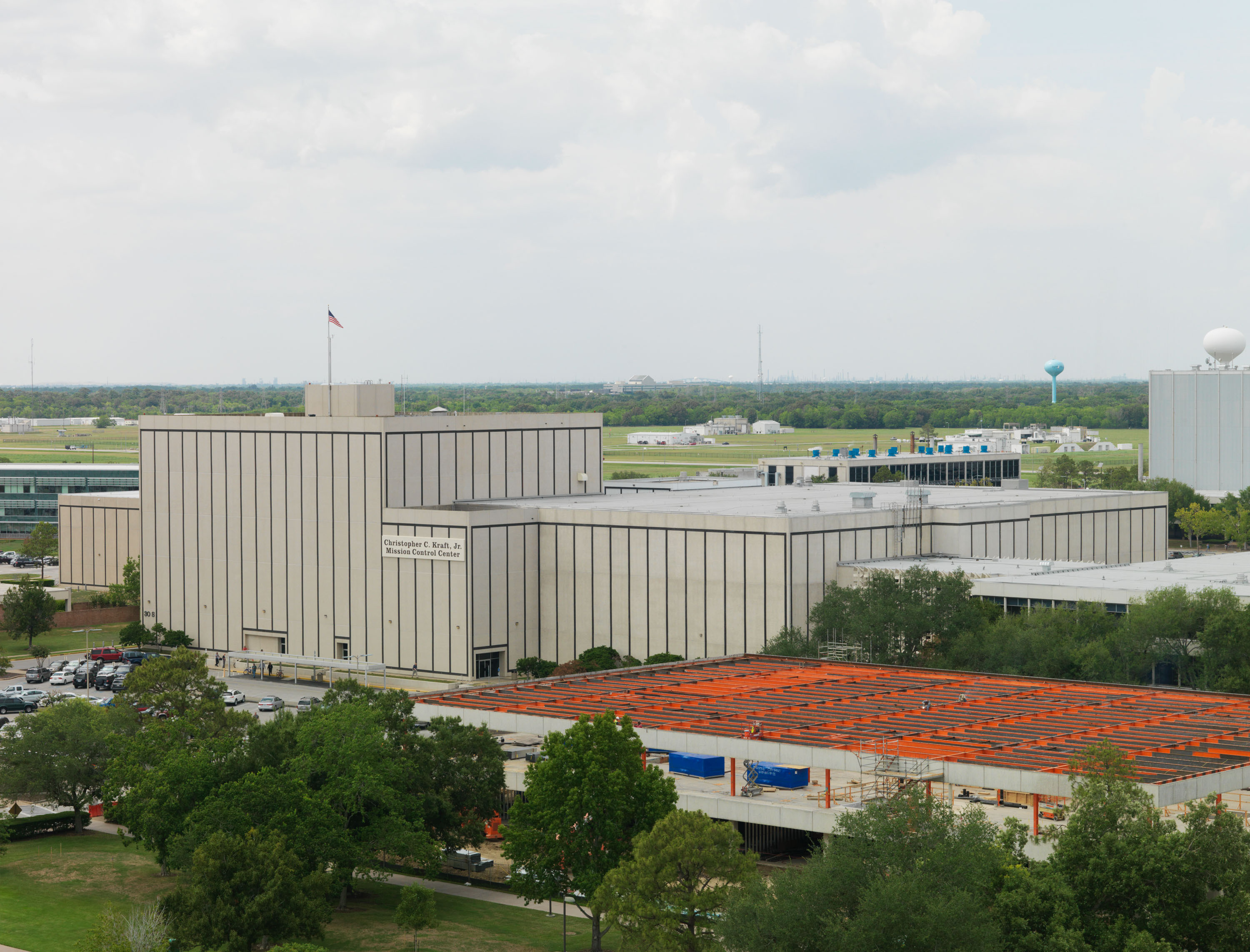 Aerial view of a large government building complex with a US flag on the roof.