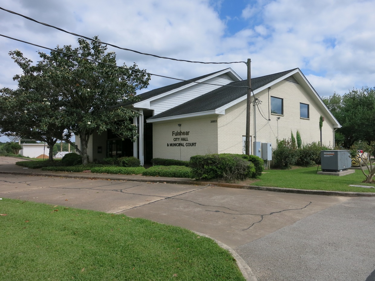 Single-story white brick building housing Fulshear City Hall and Municipal Court.