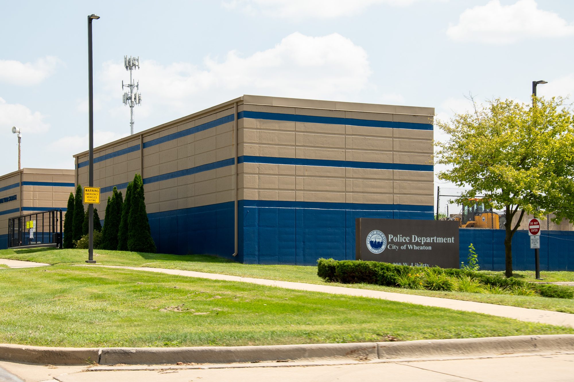 Exterior of a two-story police department building with blue and tan paneling.