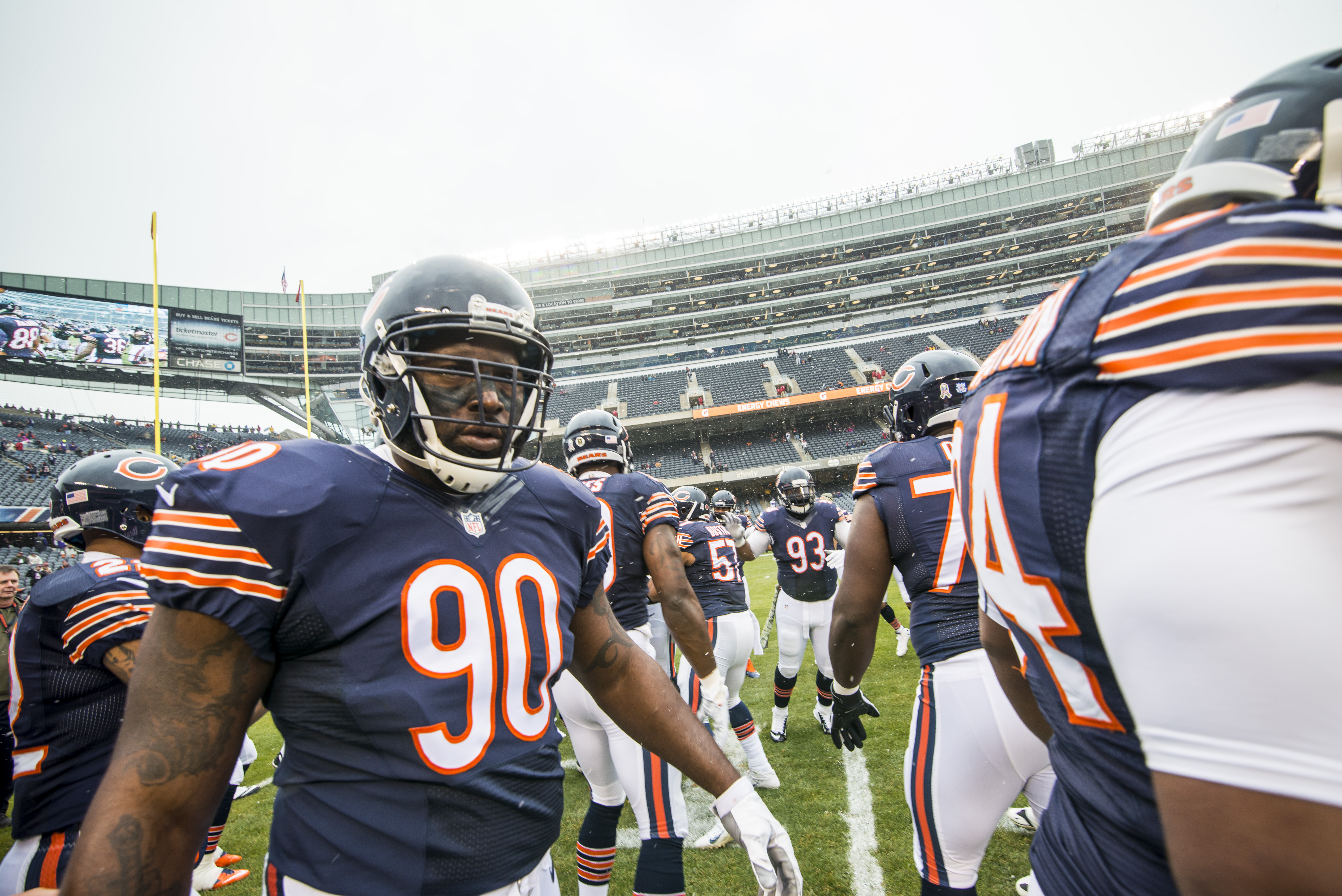 Chicago Bears players in navy and orange uniforms lined up on a football field.
