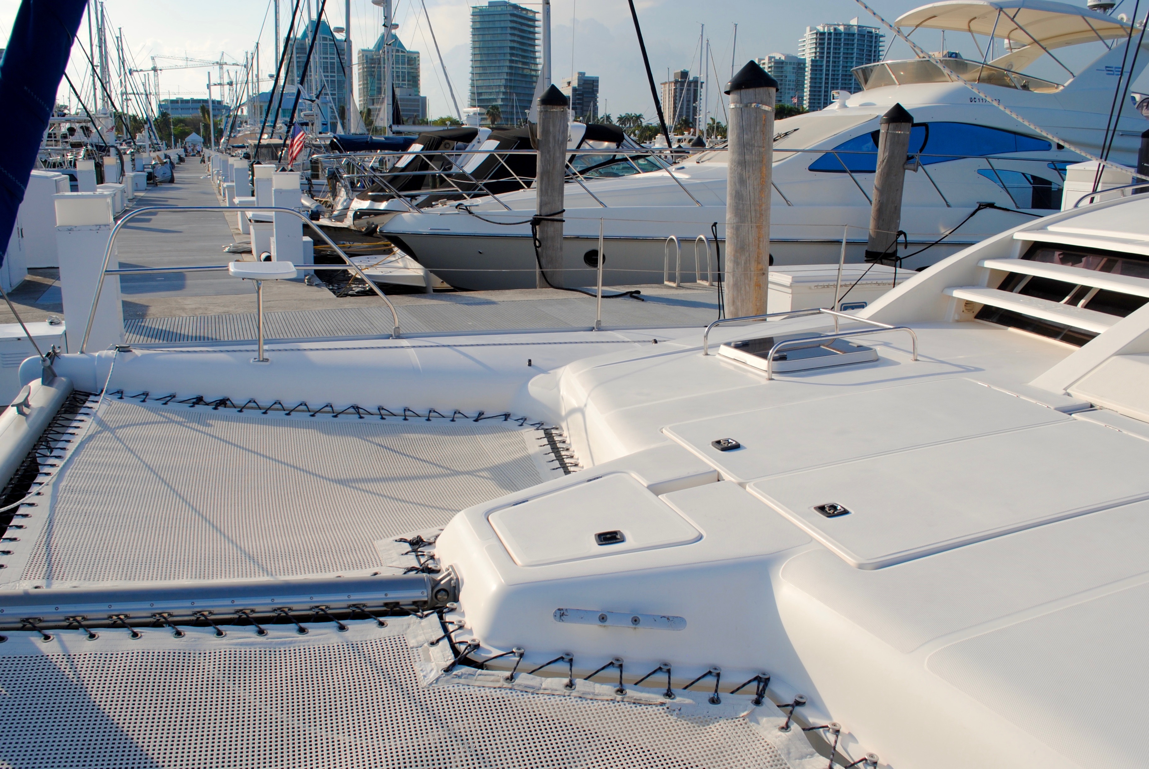 Marina dock with moored boats and Miami skyline visible in the background.