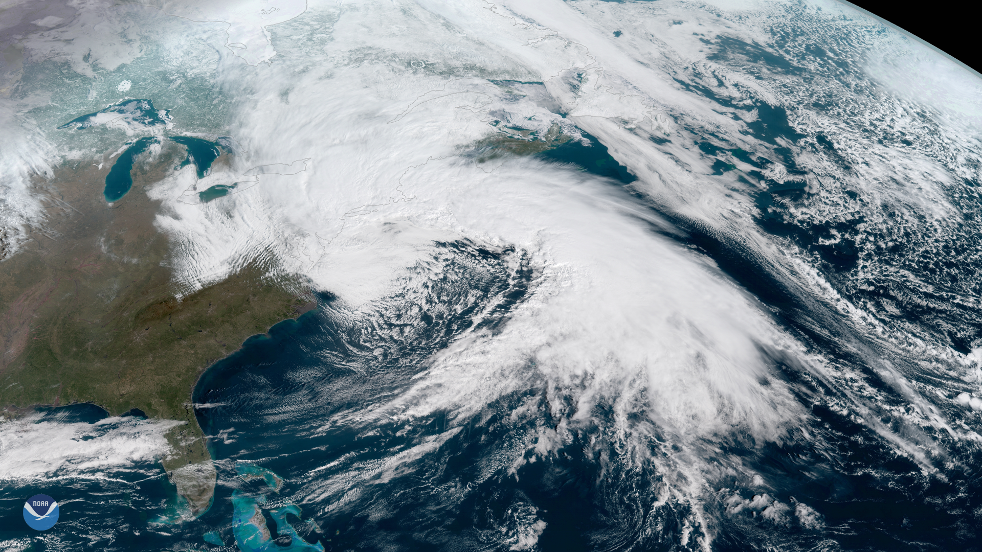 Satellite image of a large spiral storm system over the northeastern United States and Atlantic coast.