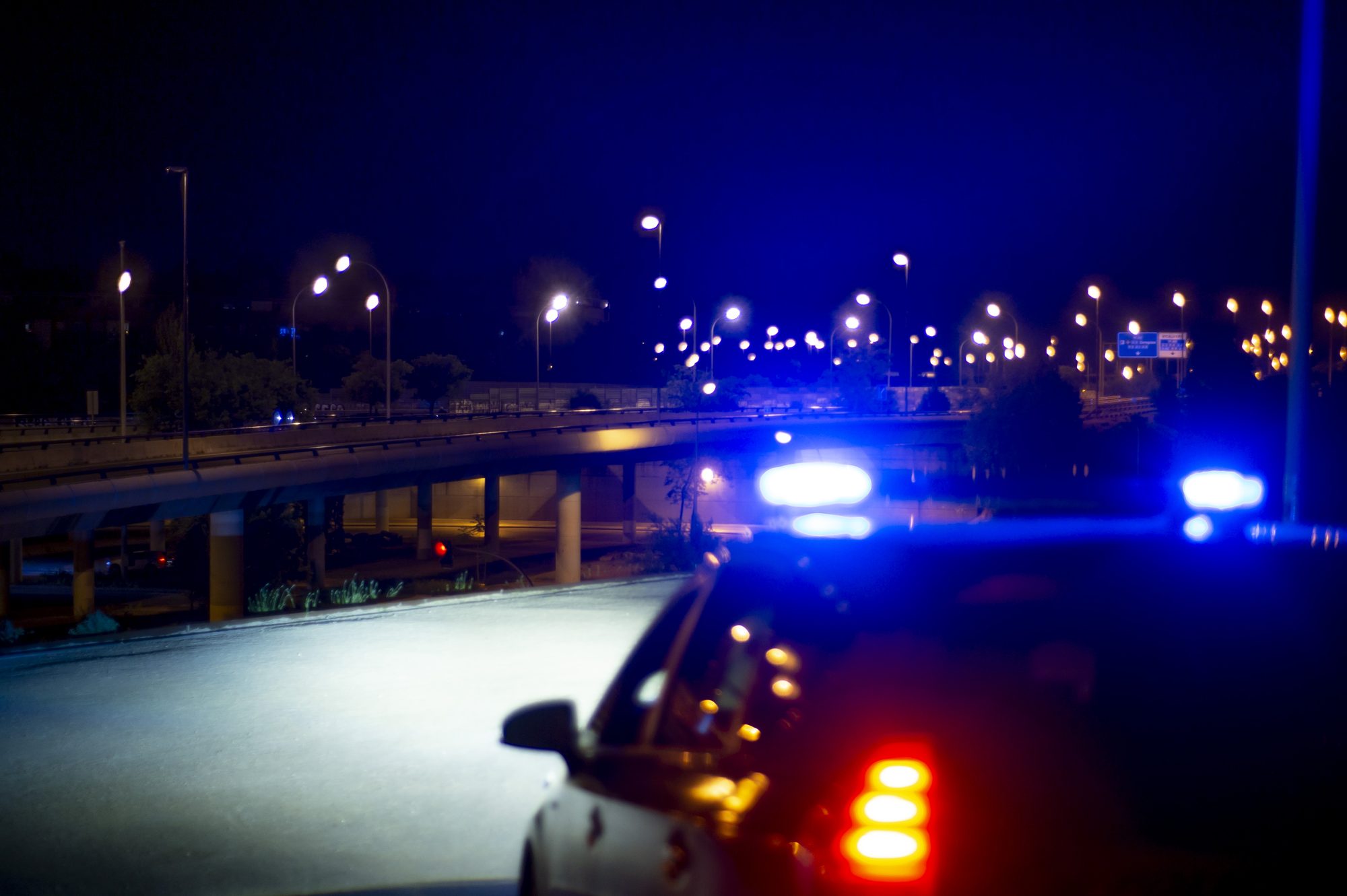 Police car with bright sirens and the city in the background