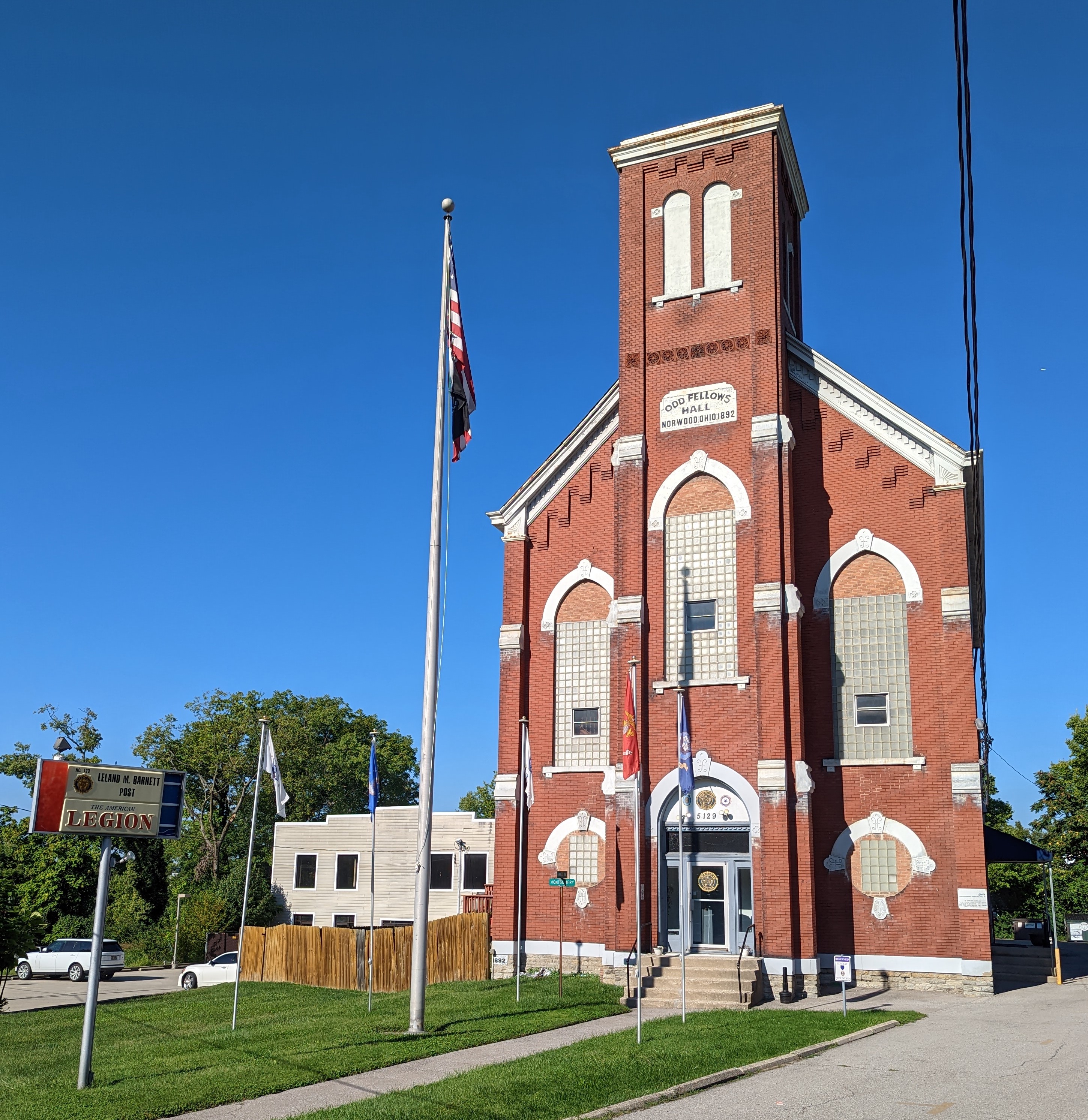Red brick American Legion post building with an American flag on a flagpole out front.