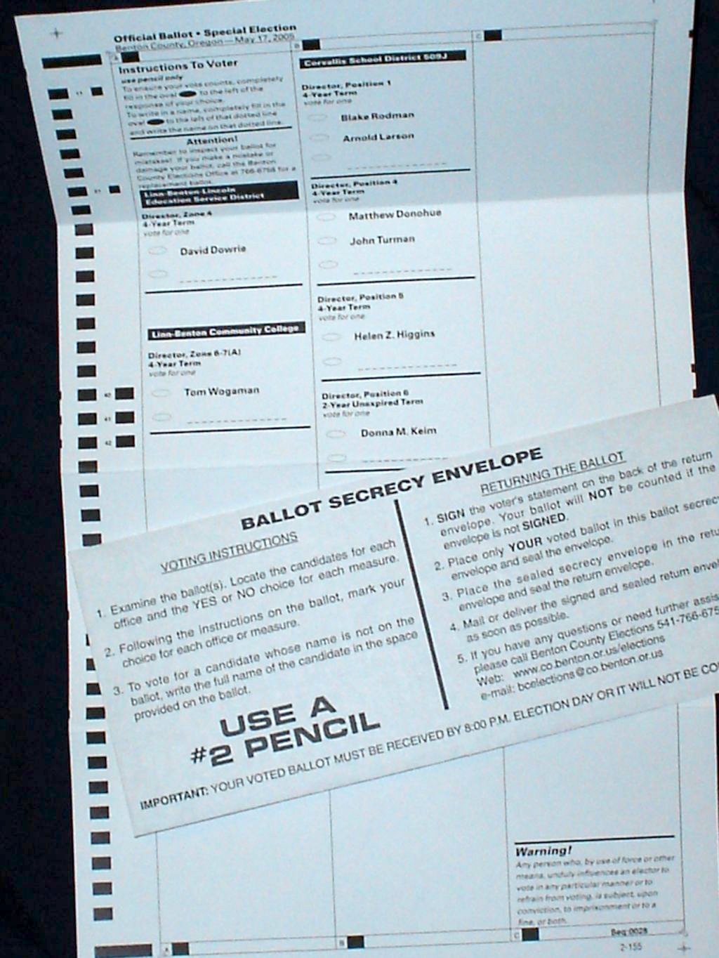 An official mail ballot, secrecy envelope, and voter instruction sheet laid flat.