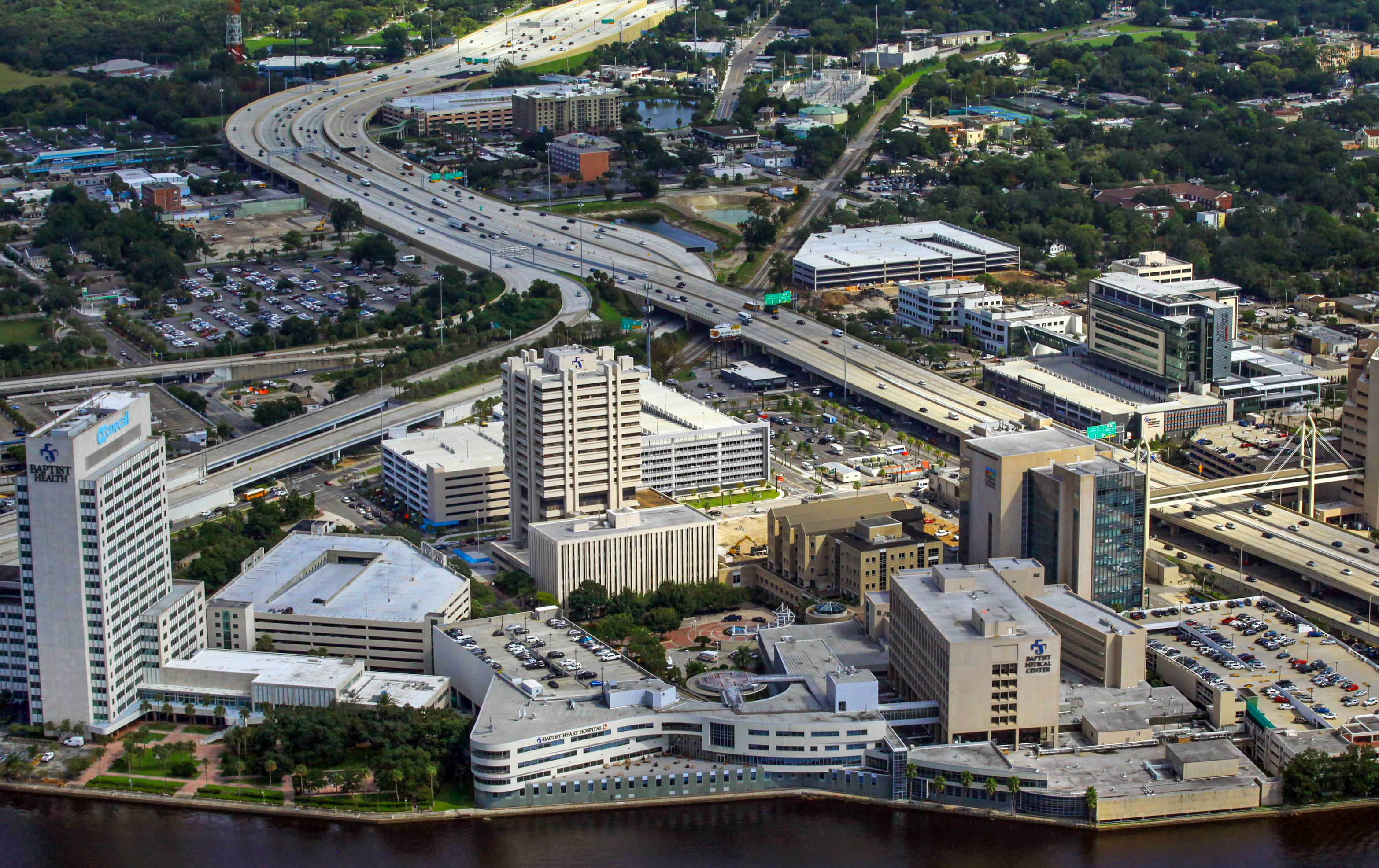 Aerial view of a large hospital campus with multiple buildings along a river.