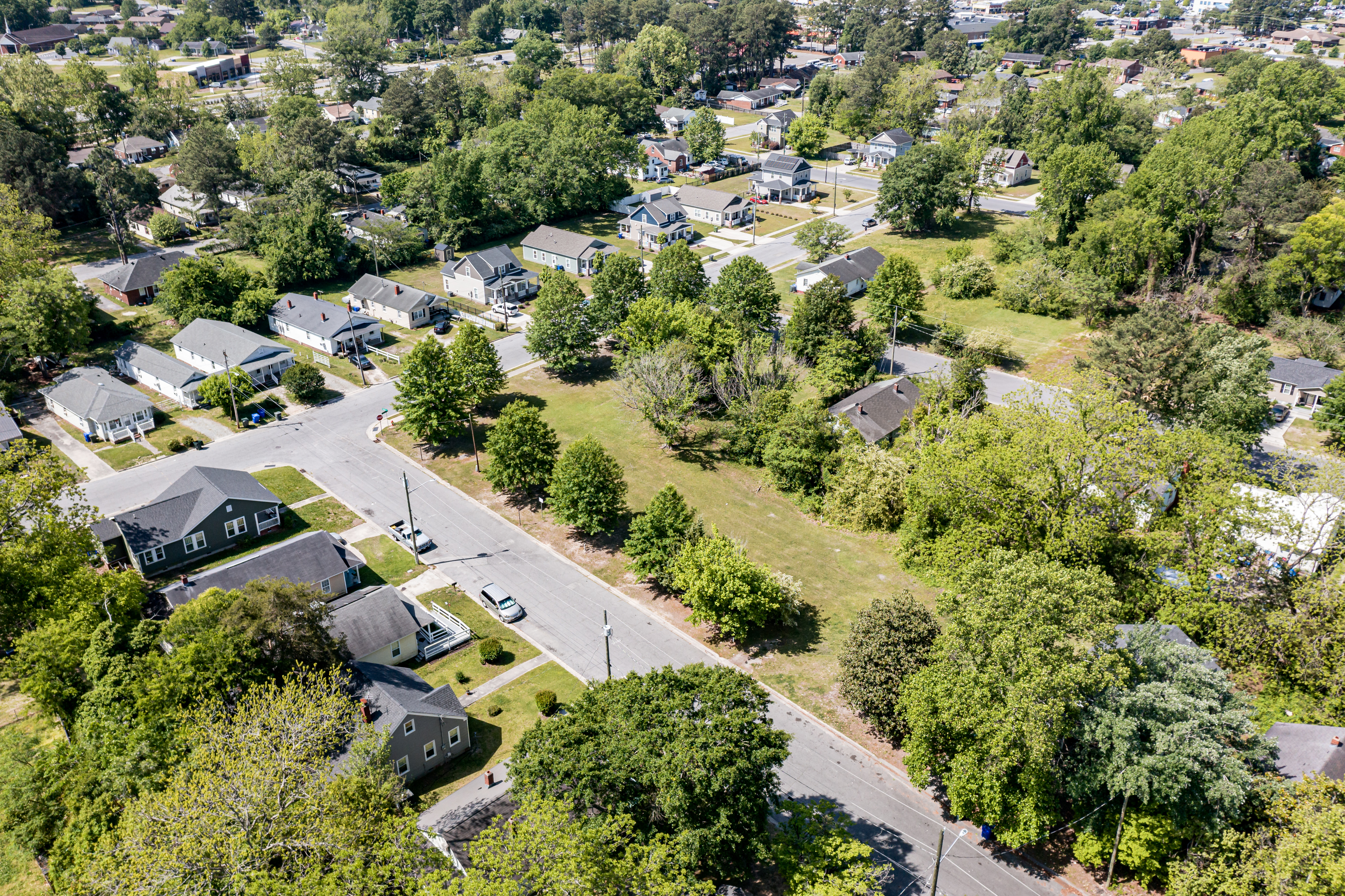 Aerial view of a suburban neighborhood with single-family homes and tree-lined streets.