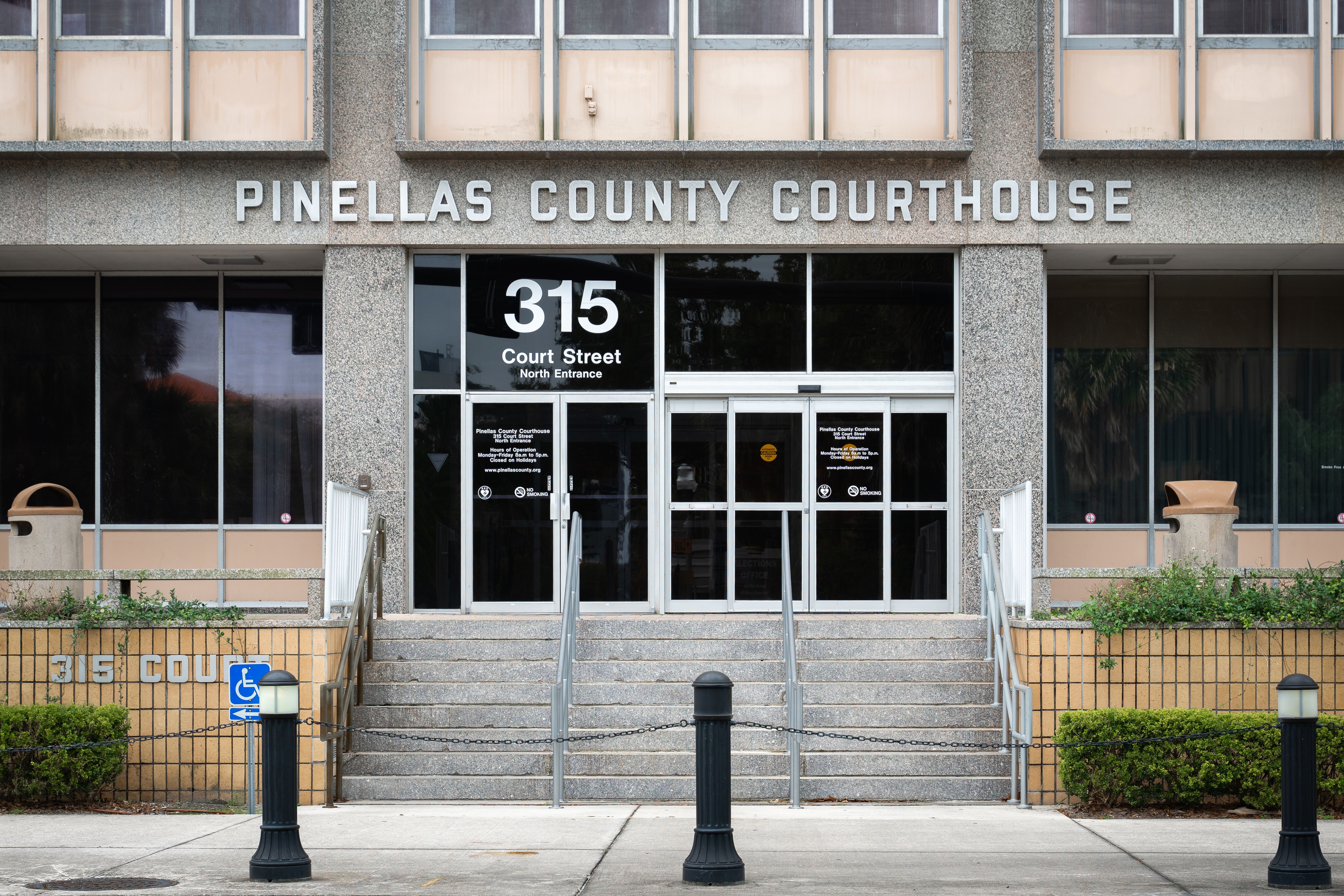 Exterior of the Pinellas County Courthouse north entrance with steps and bollards.