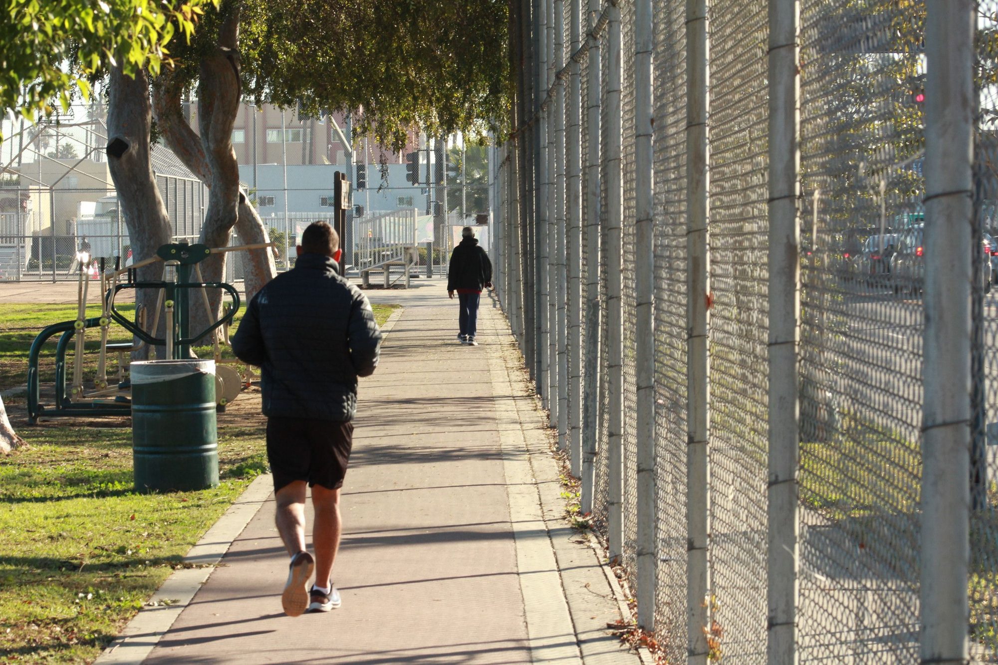 Morning joggers on a sunlit sidewalk in Los Angeles, capturing urban lifestyle and fitness.